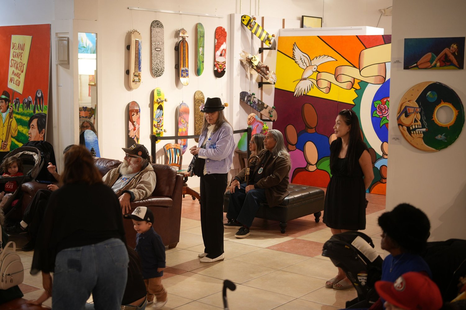 Visitors gather among painted skateboard decks and artwork.