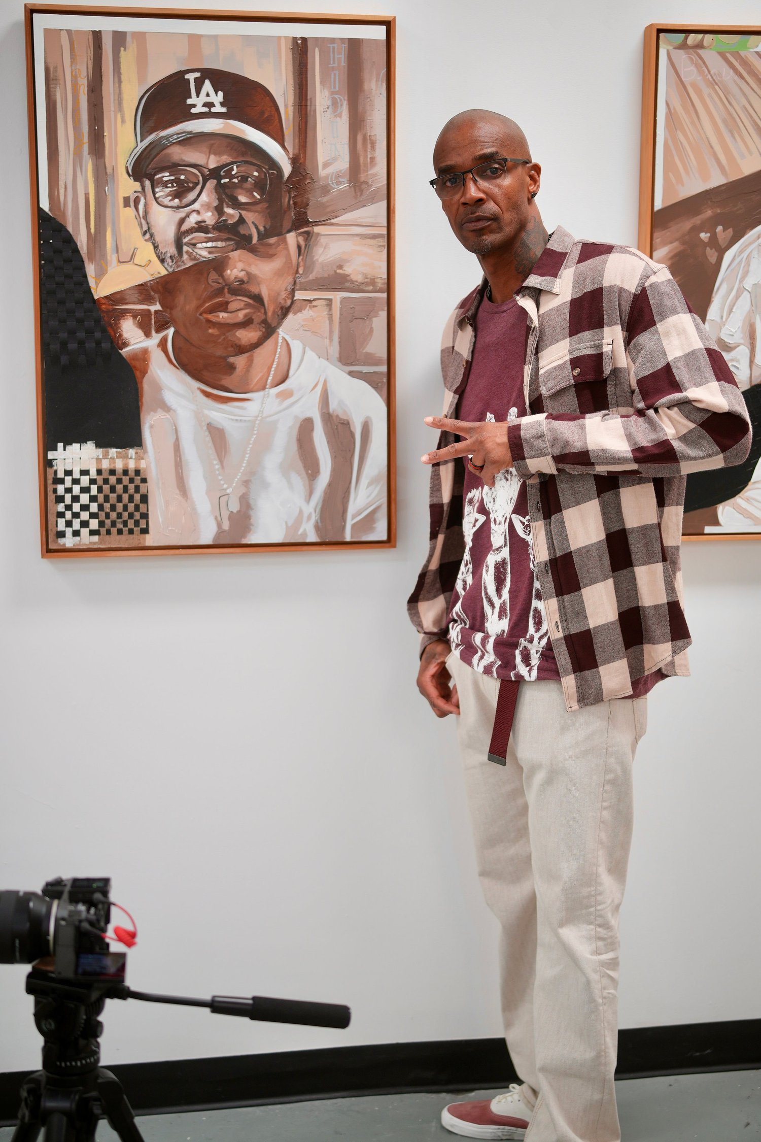 A speaker stands beside a framed portrait.
