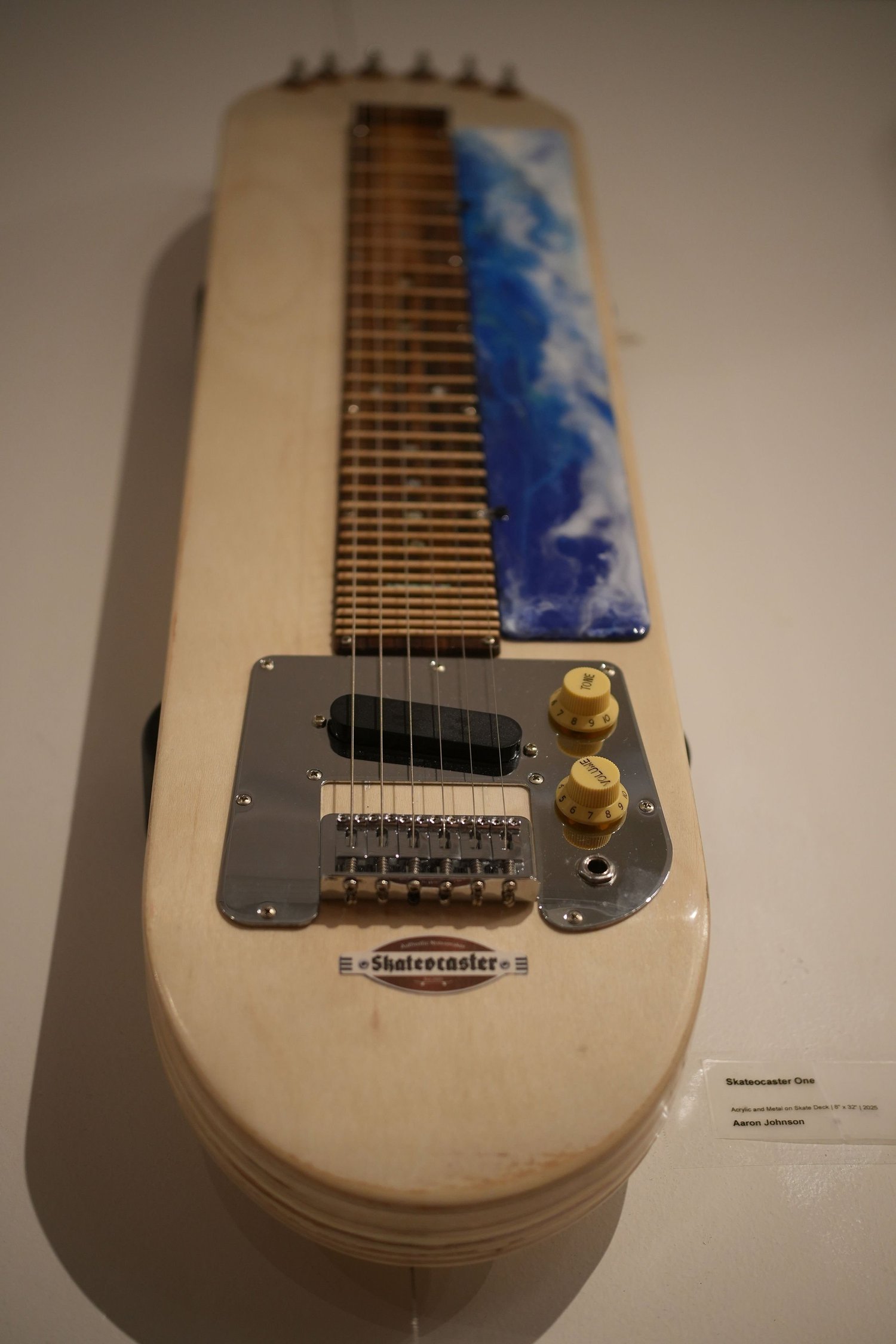 A stringed instrument made from a skateboard deck.
