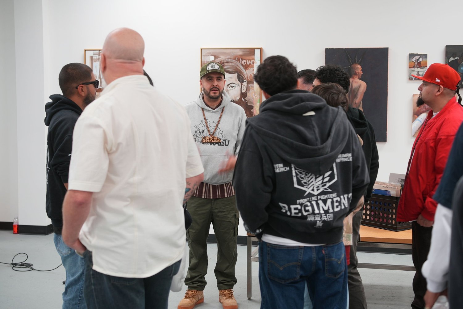 Visitors converse in a group beside the artwork.