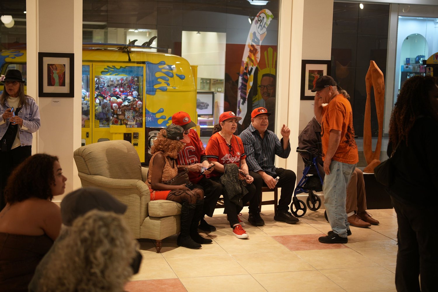 Guests gather around chairs in the gallery.