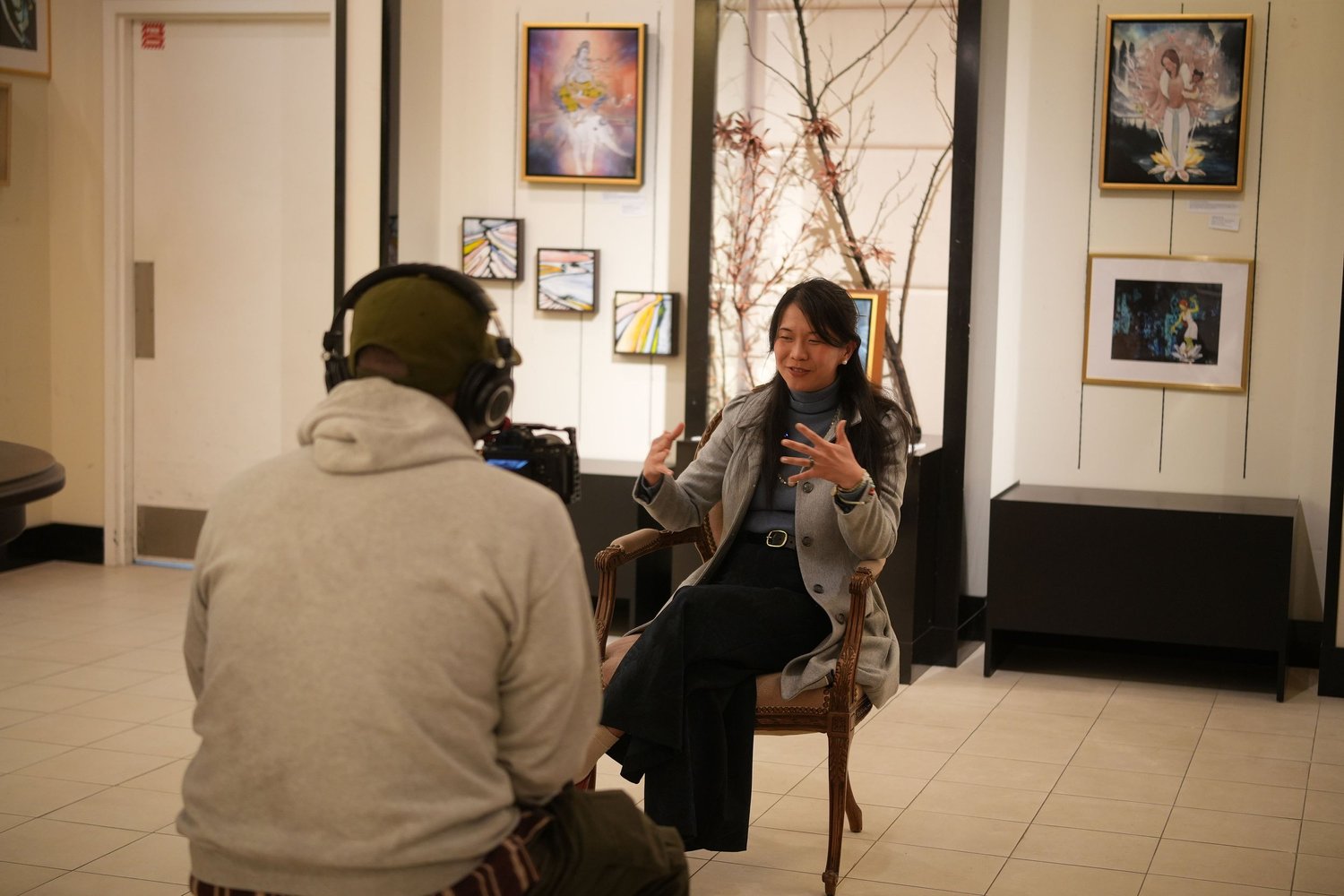 A seated interviewer gestures while speaking.