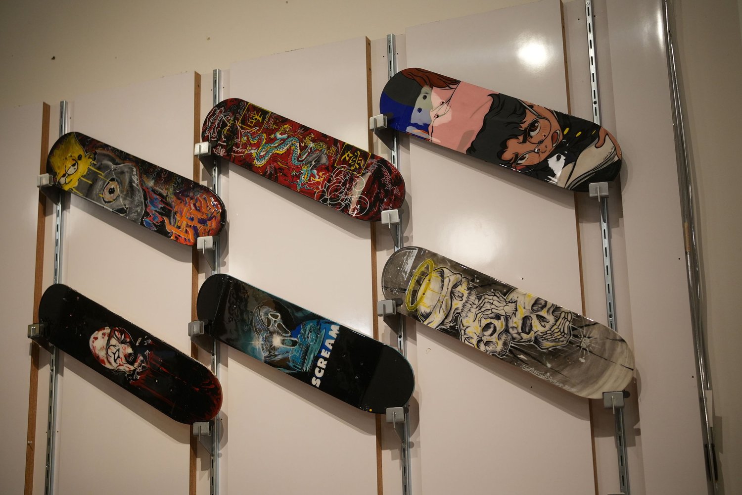 Painted skateboard decks mounted on the wall.