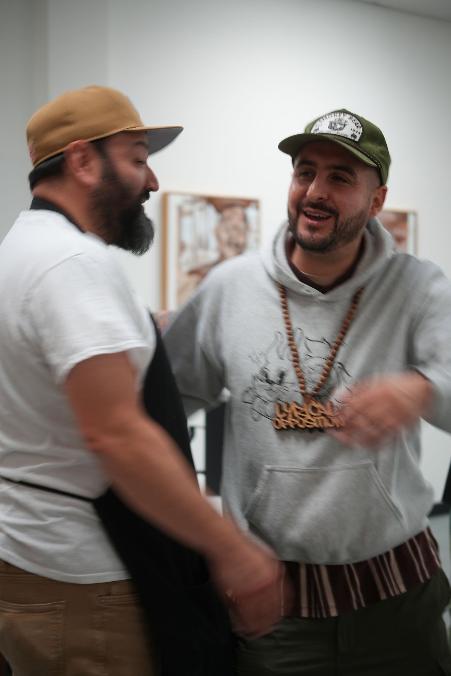 Two guests greet each other in the gallery.