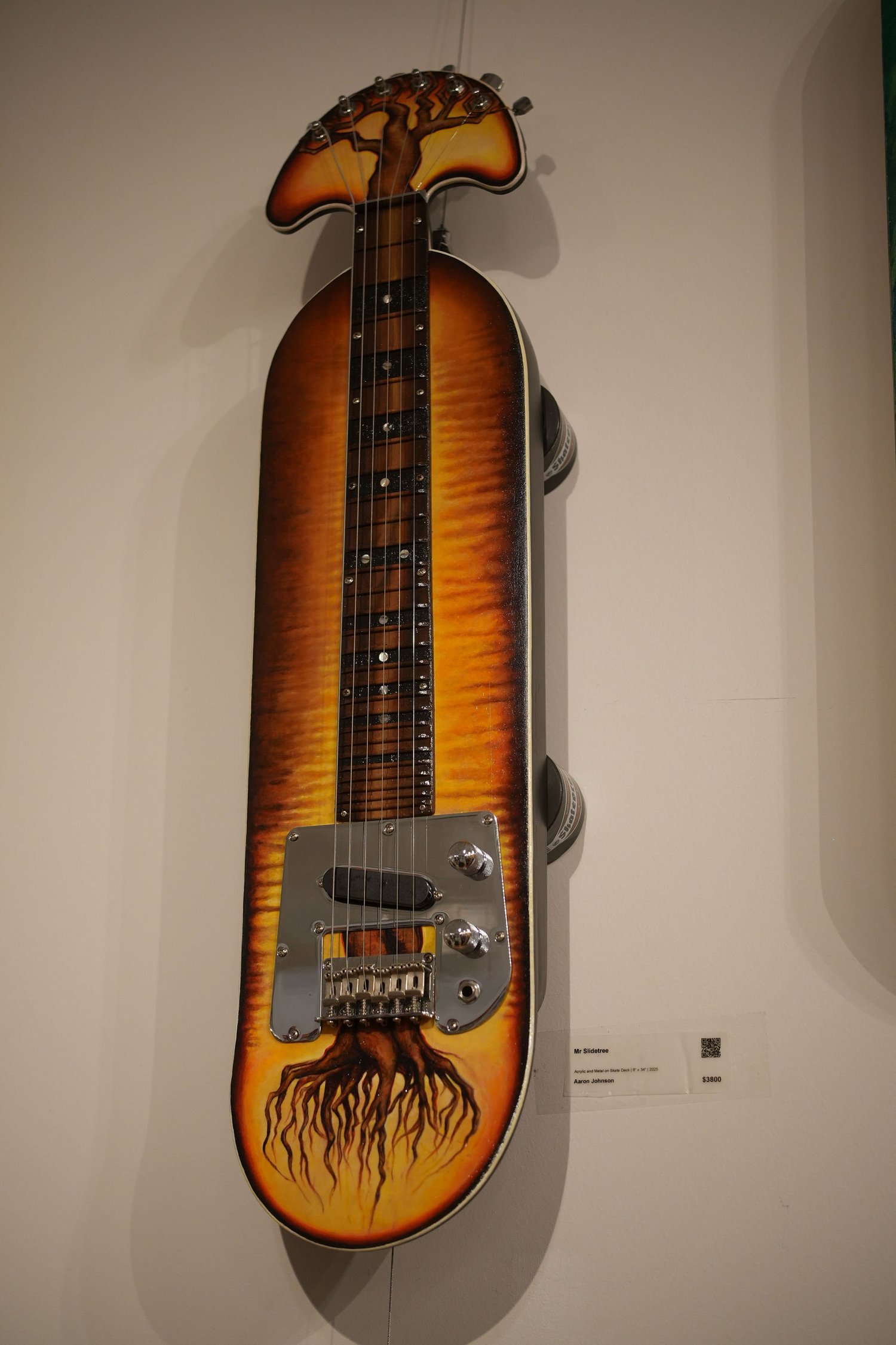 A decorated skateboard transformed into a stringed instrument.