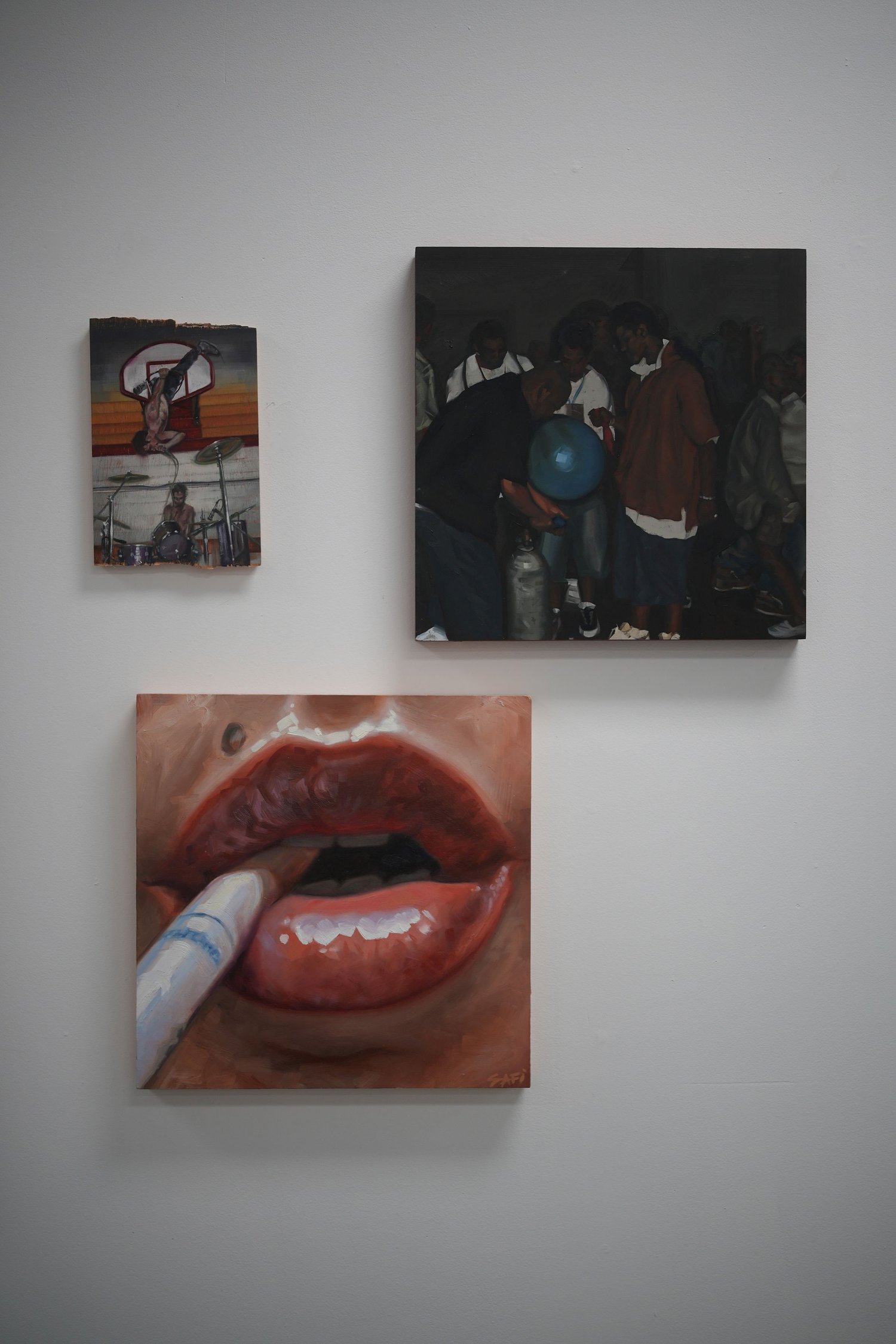 Three paintings displayed together on a white wall.