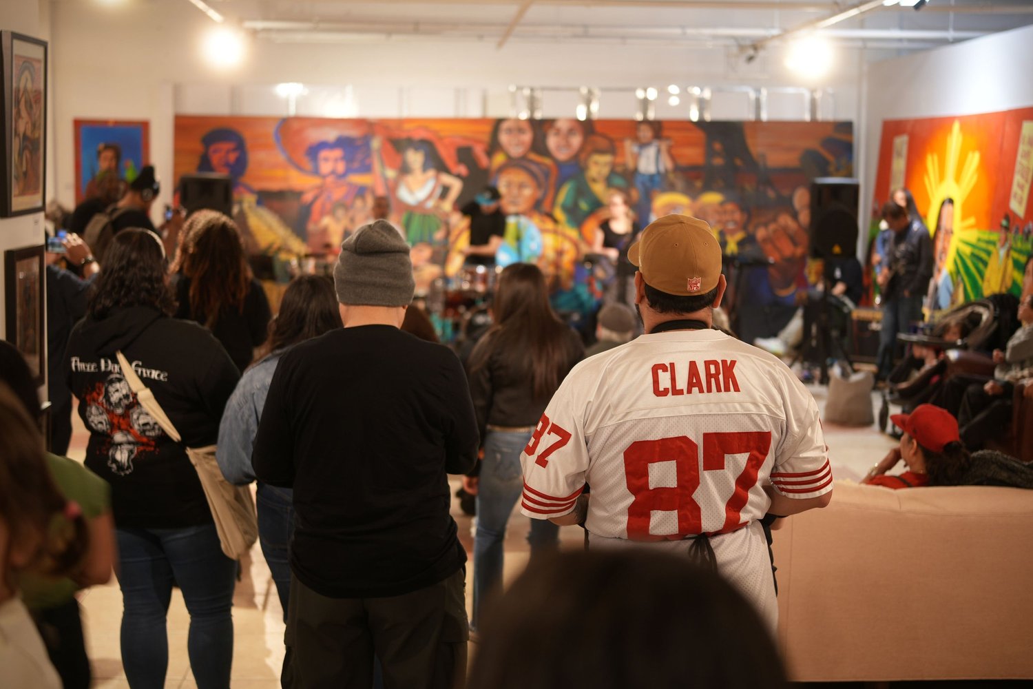 Guests watch the band beneath the gallery mural.