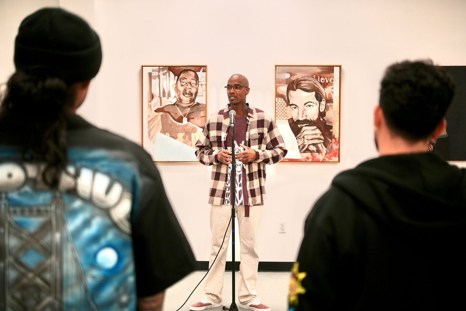 Audience members listen to a speaker at the microphone.
