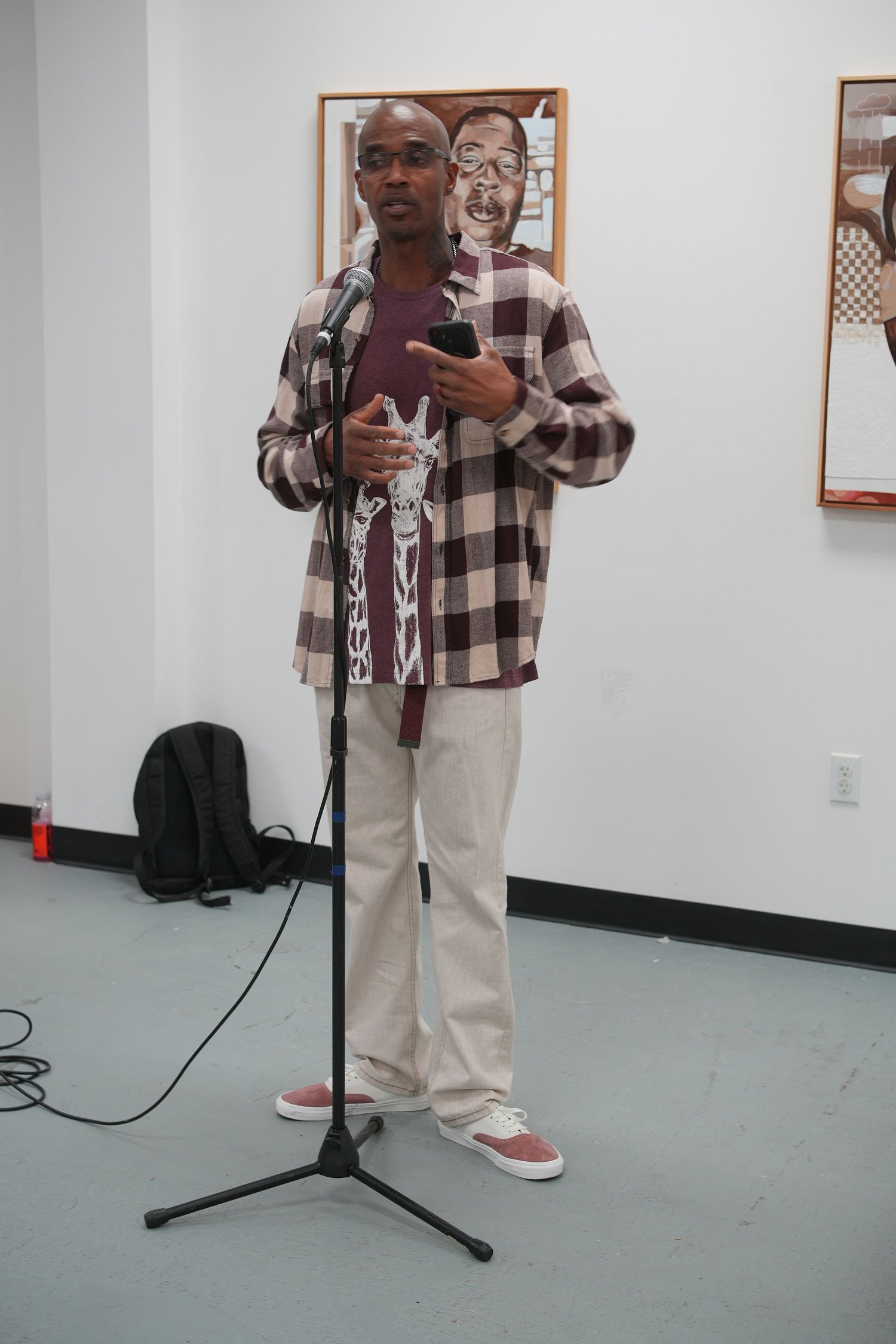 A speaker reads from a phone at the microphone.
