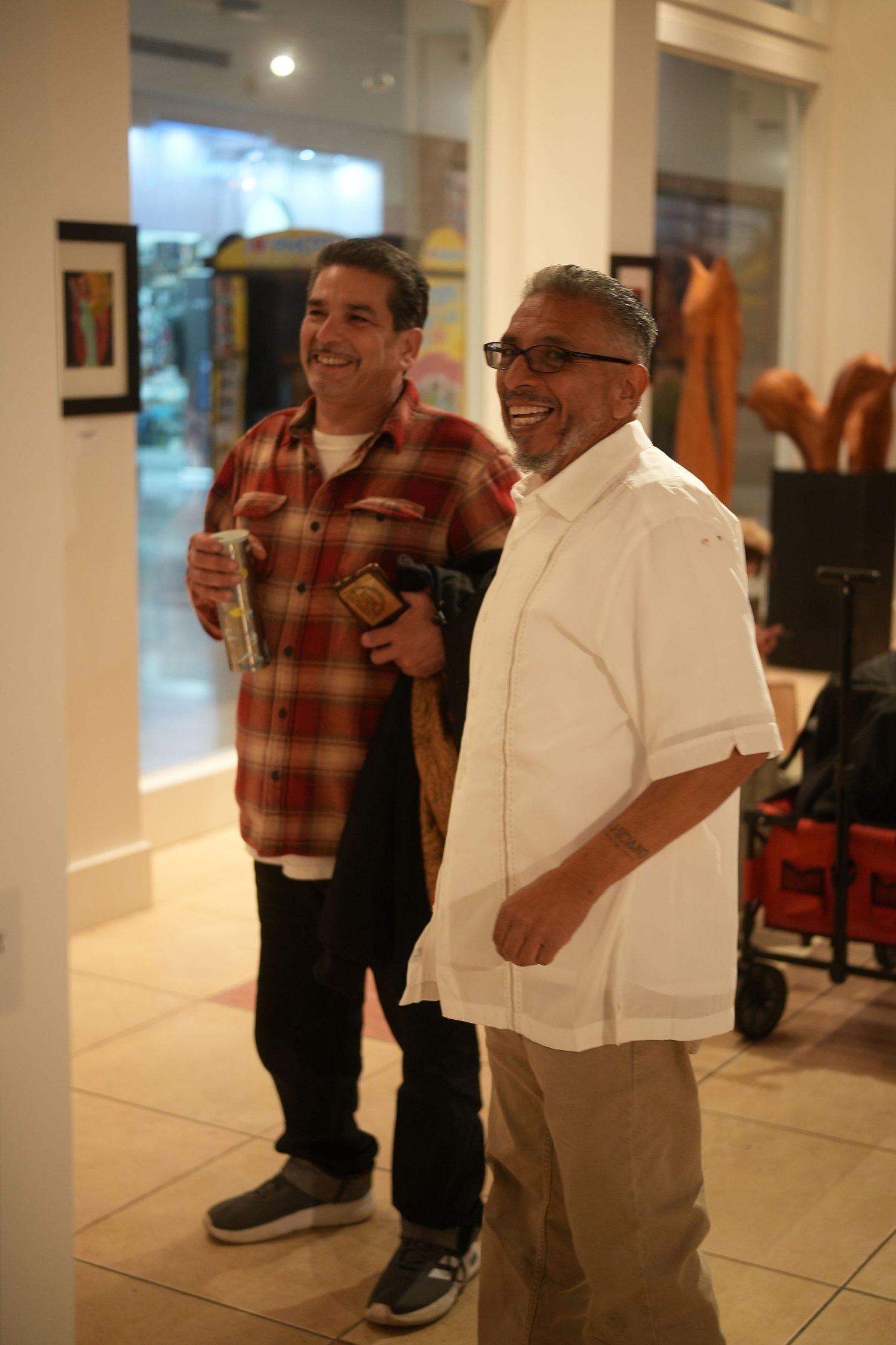 Two visitors converse near the gallery entrance.
