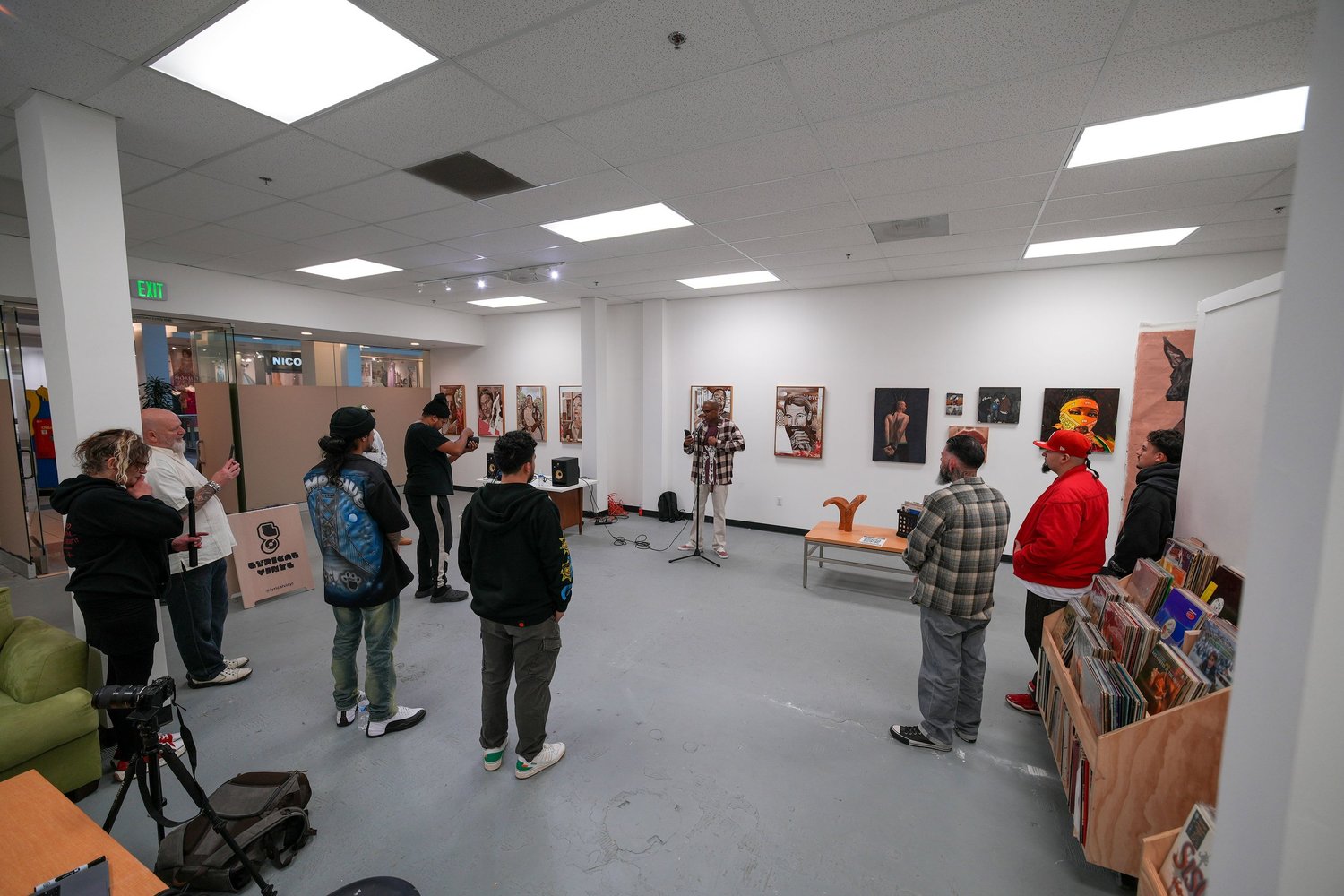 Wide view of visitors in the white-walled gallery.