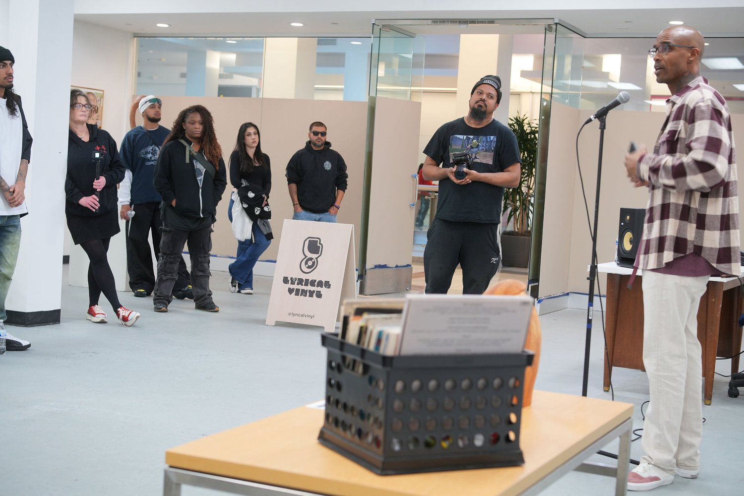 A speaker addresses gallery visitors with a microphone.