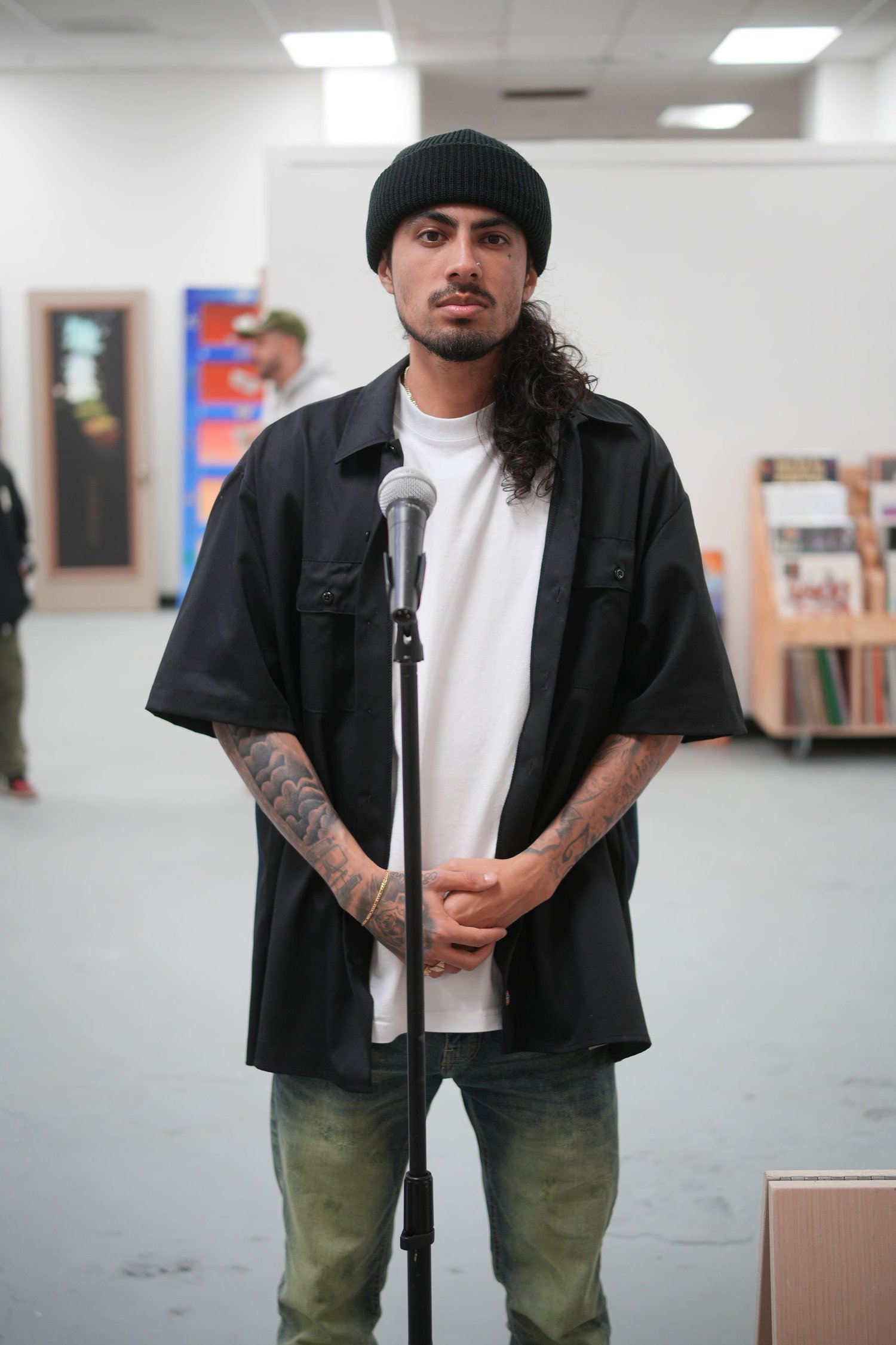 An artist poses in front of the exhibition artwork.