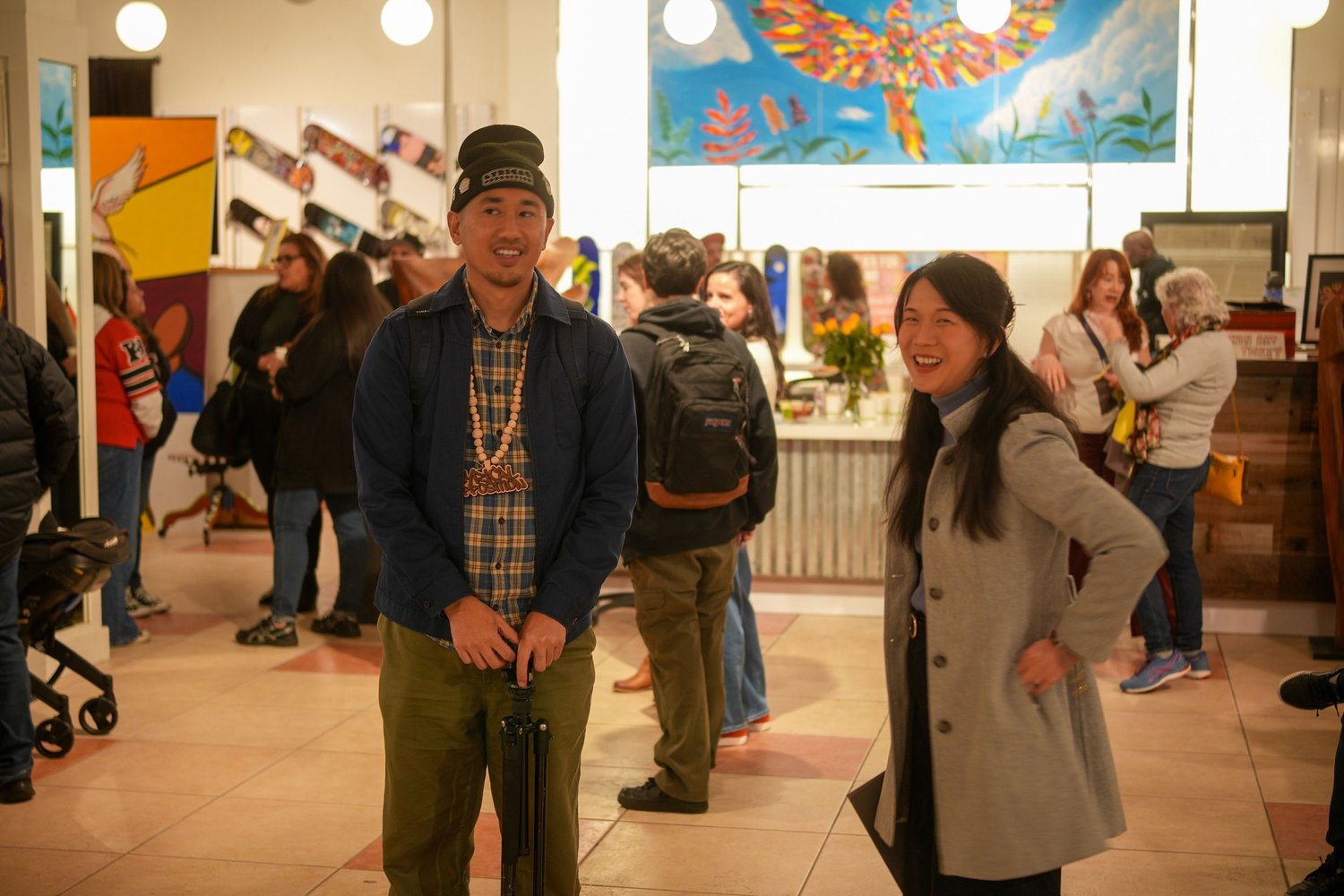 Visitors mingle beneath colorful artwork.