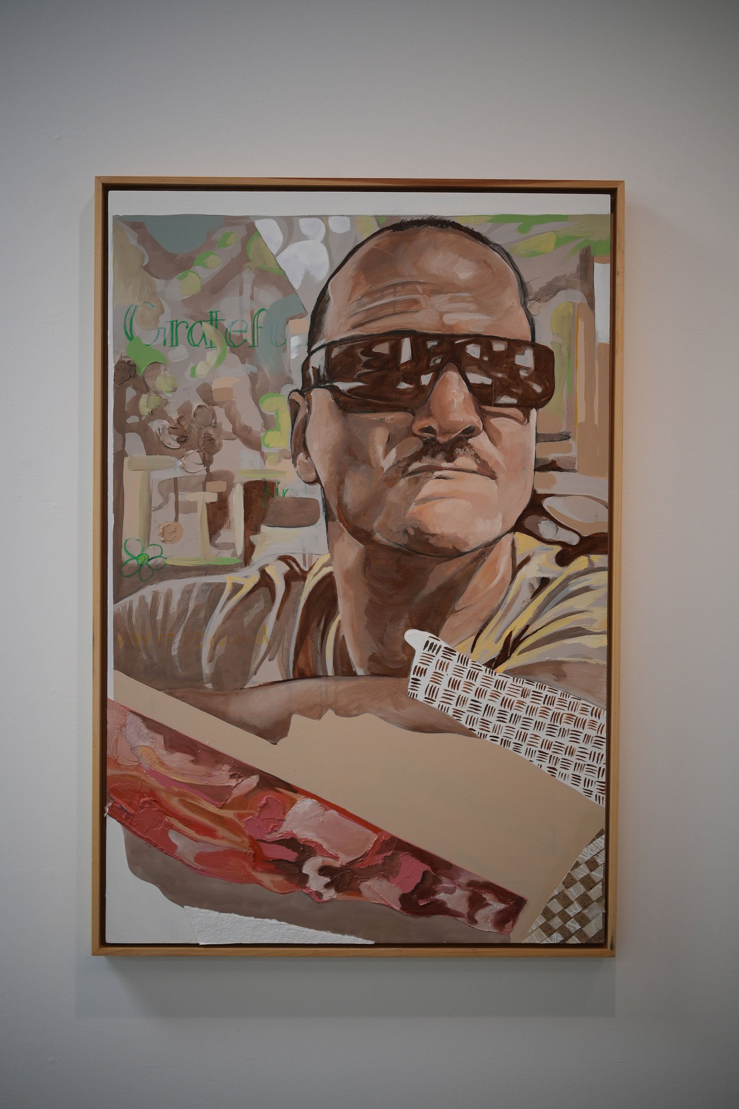A framed painted portrait of a person wearing sunglasses.