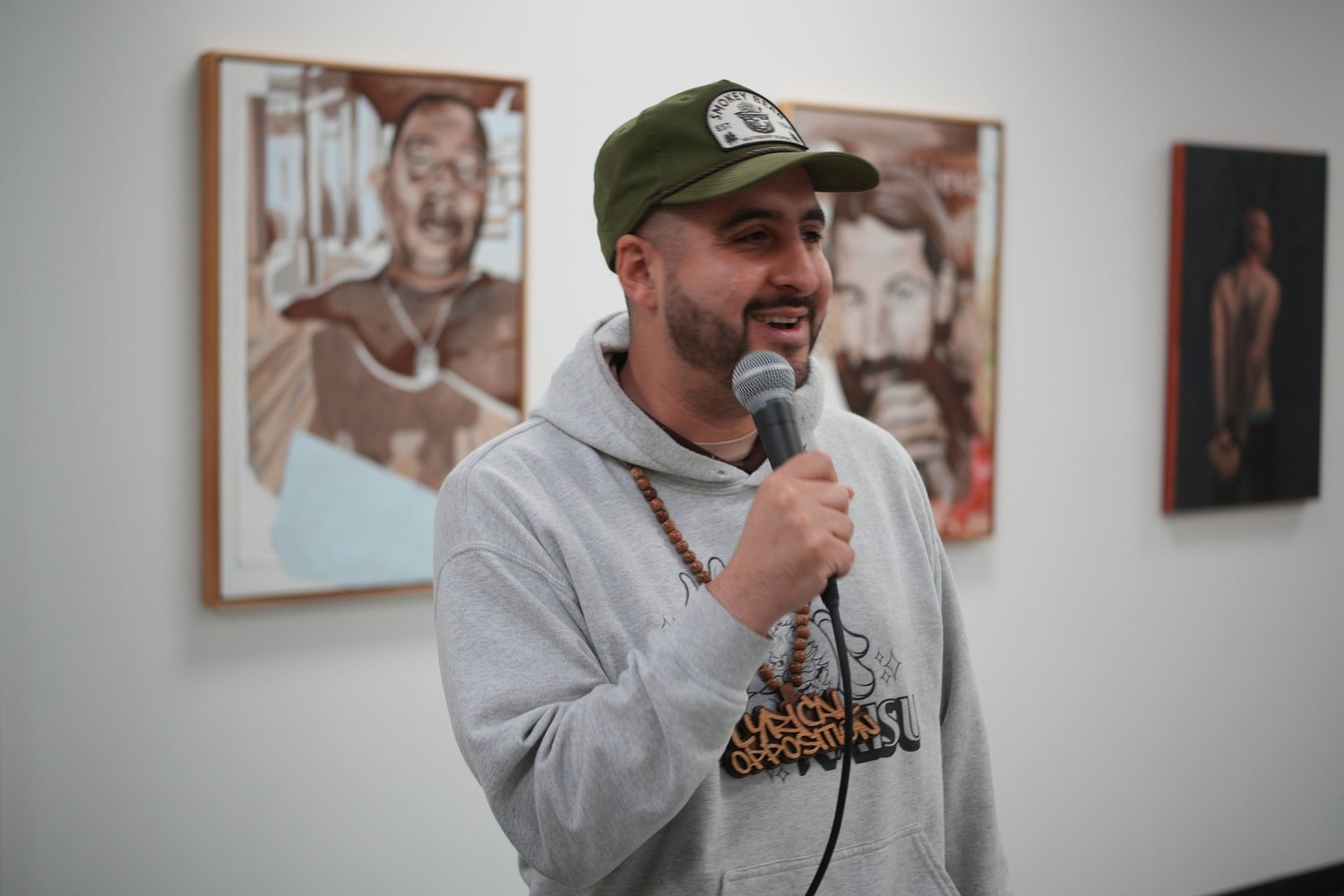 A speaker addresses gallery visitors with a microphone.