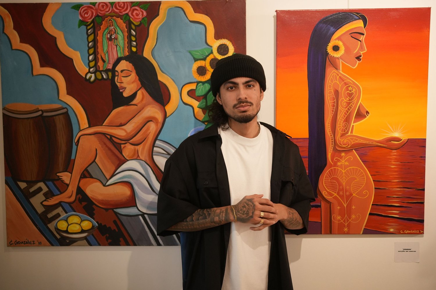 An artist poses in front of the exhibition artwork.