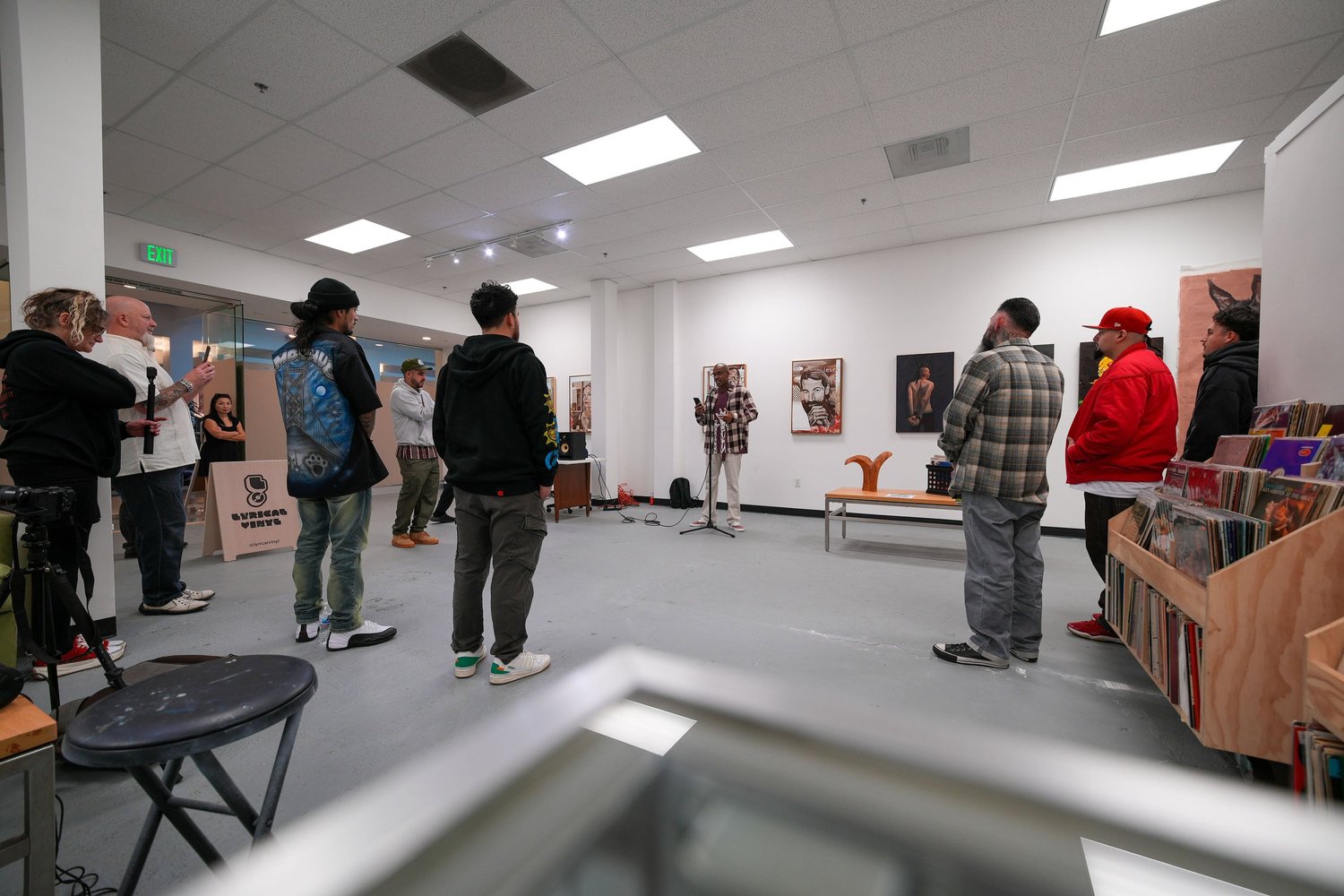 Guests gather and talk among the displayed artwork.