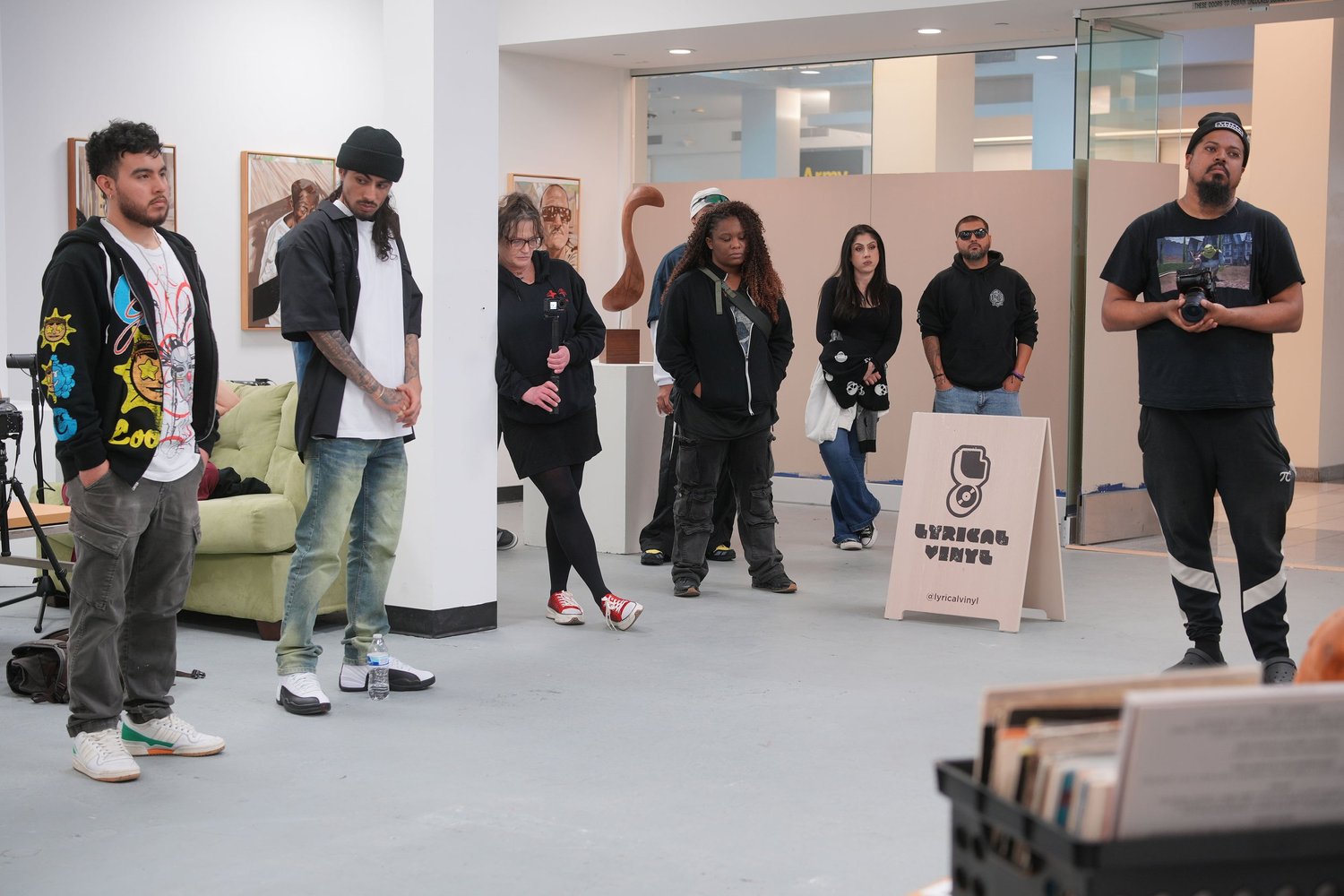 A speaker addresses gallery visitors with a microphone.