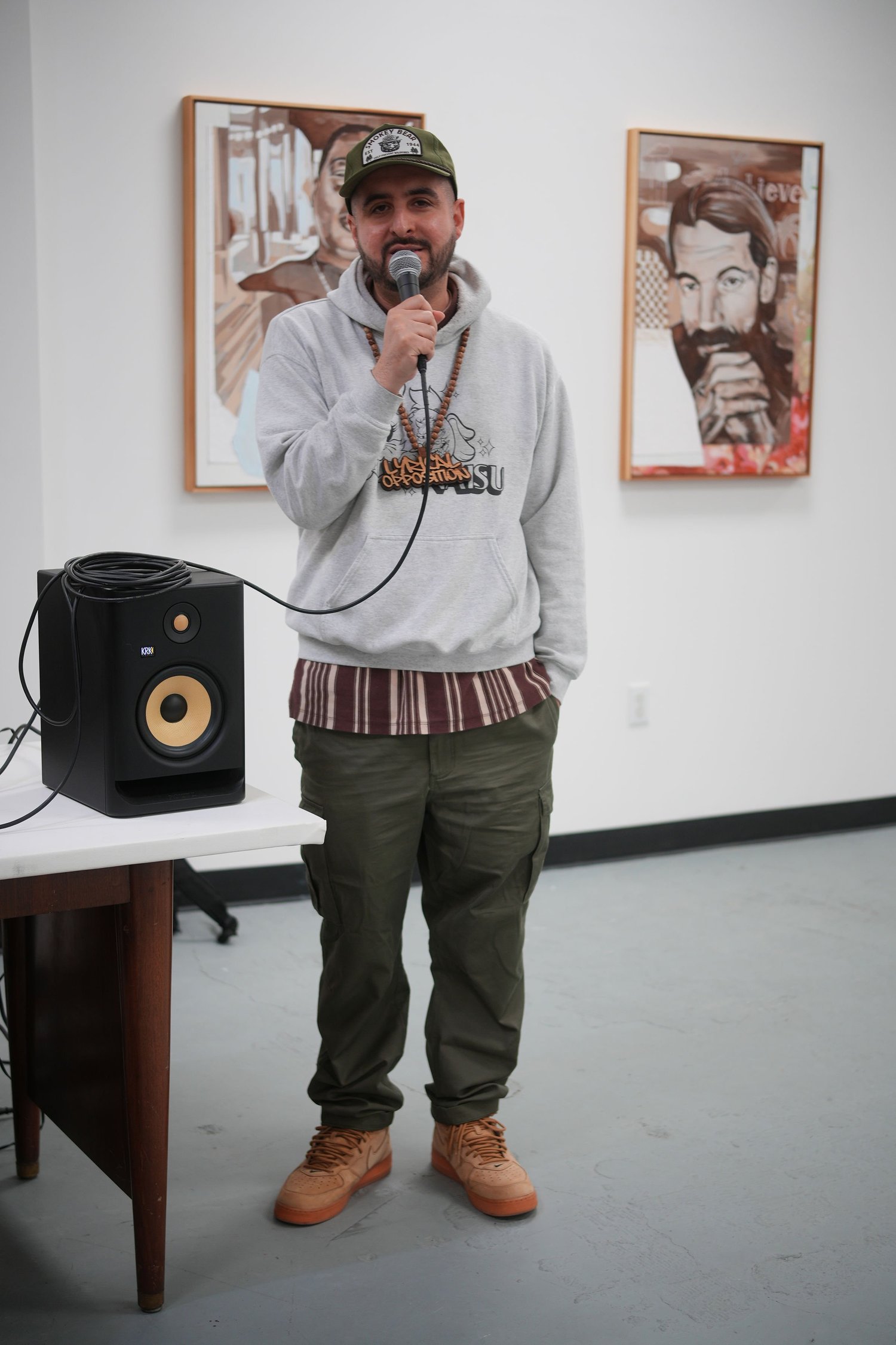 A speaker addresses gallery visitors with a microphone.
