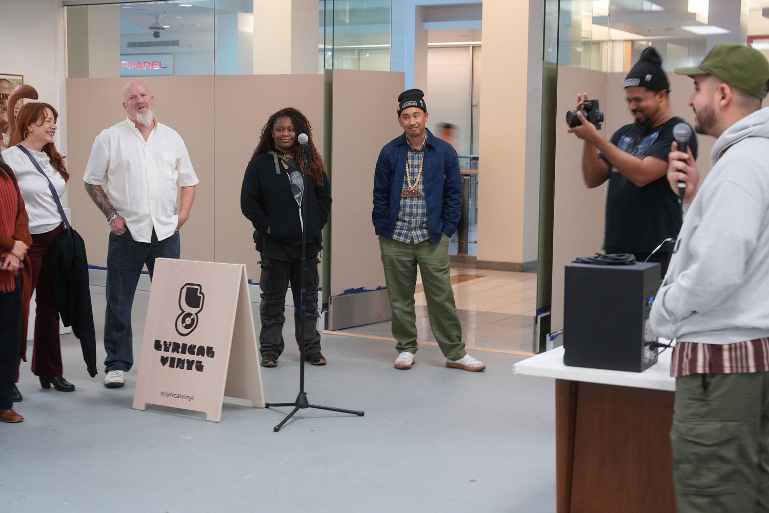 A speaker addresses gallery visitors with a microphone.