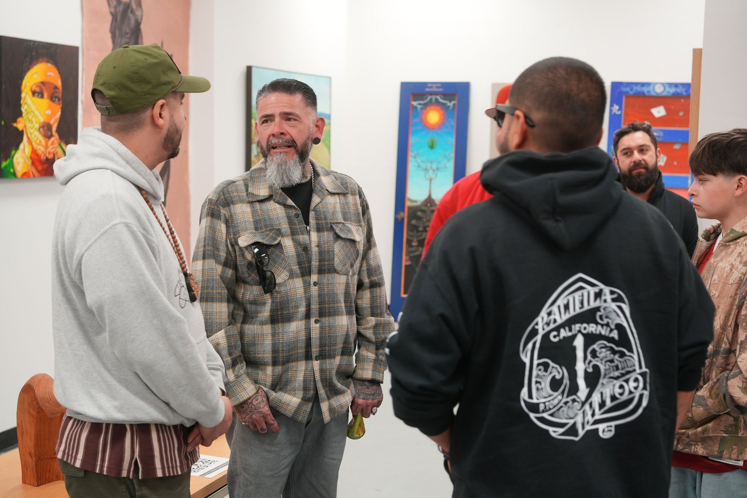 Guests gather and talk among the displayed artwork.