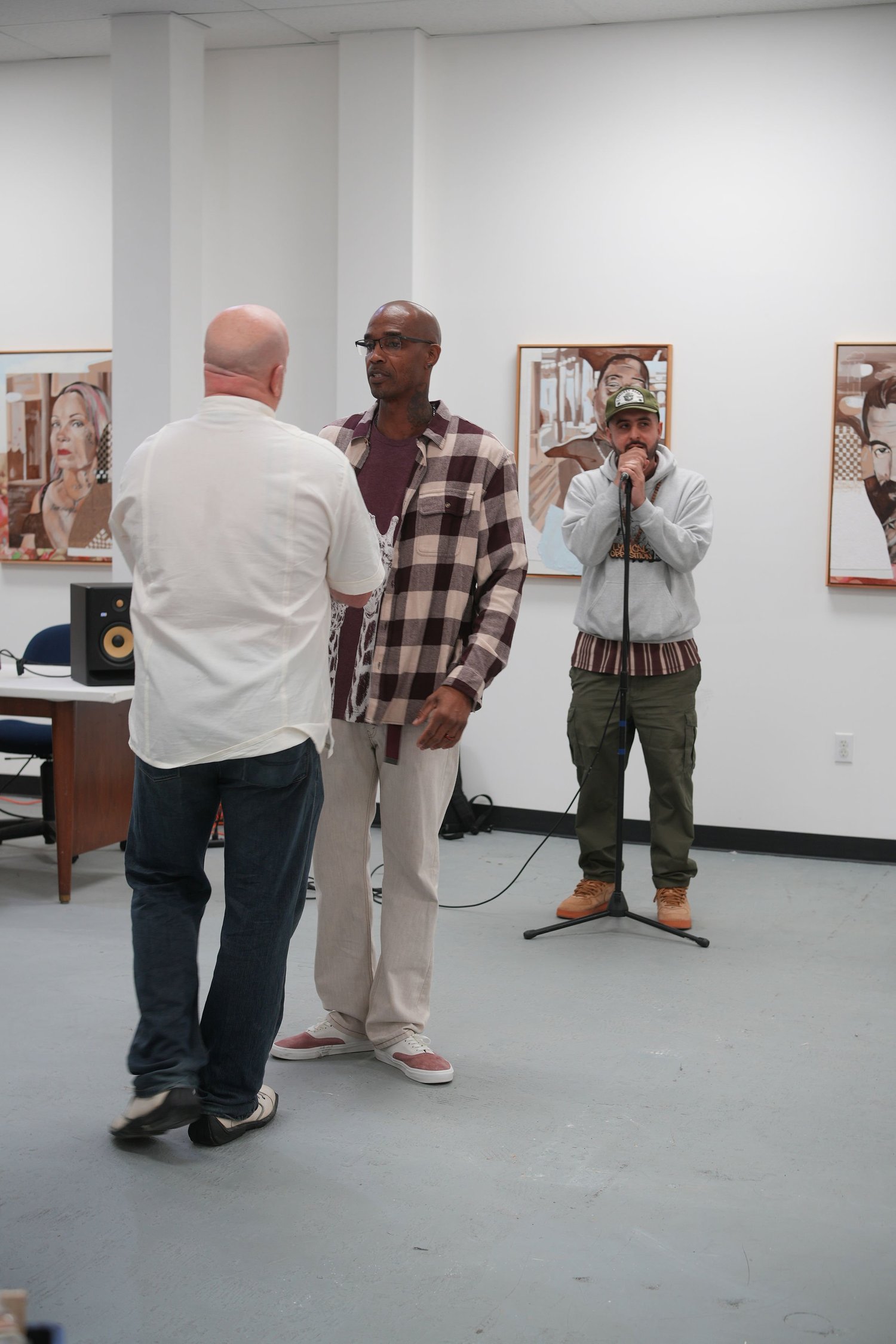 Guests gather and talk among the displayed artwork.