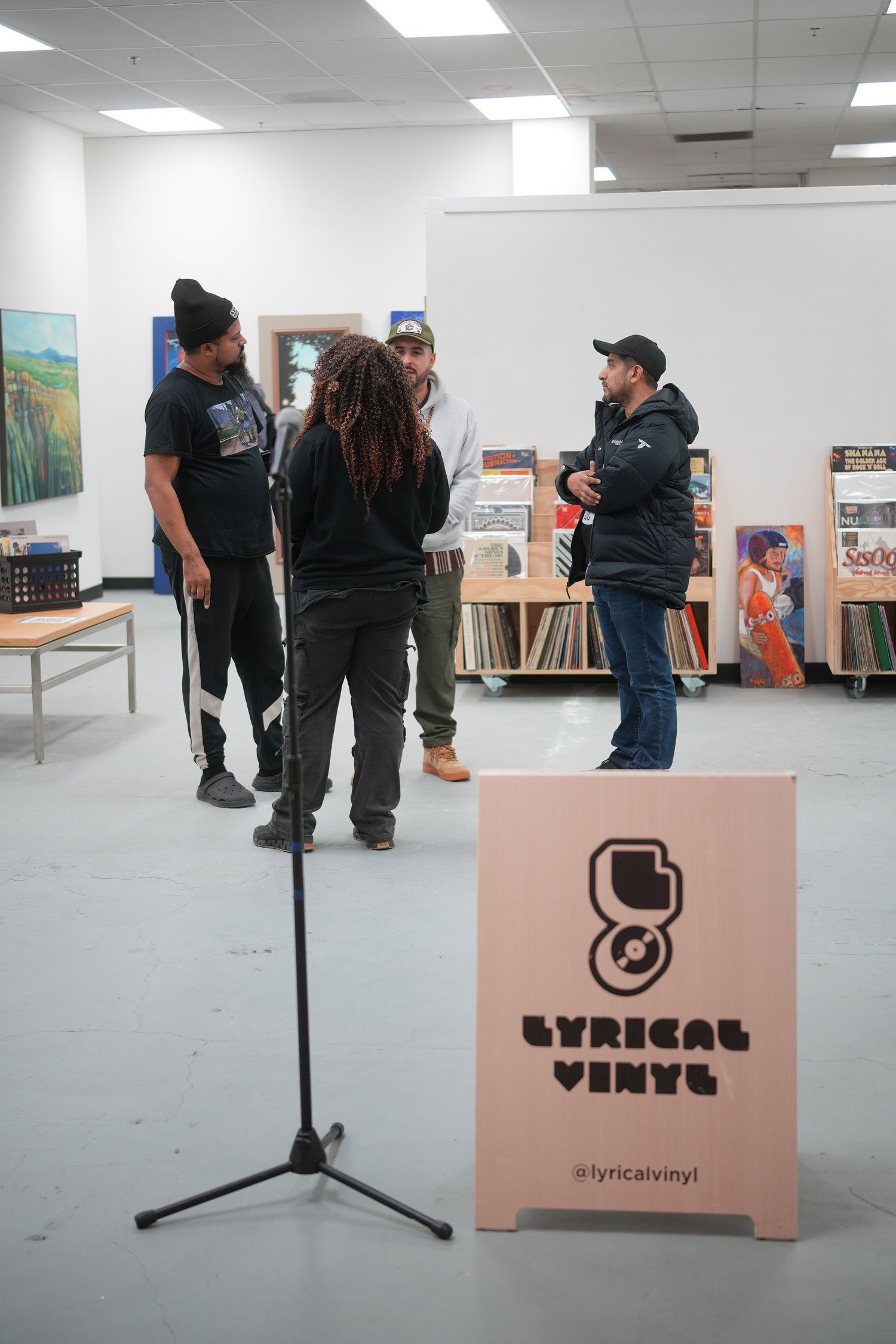 Guests gather and talk among the displayed artwork.