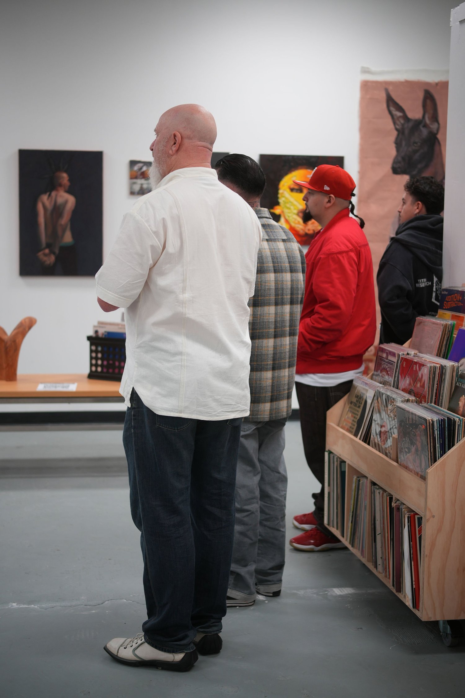 Guests gather and talk among the displayed artwork.