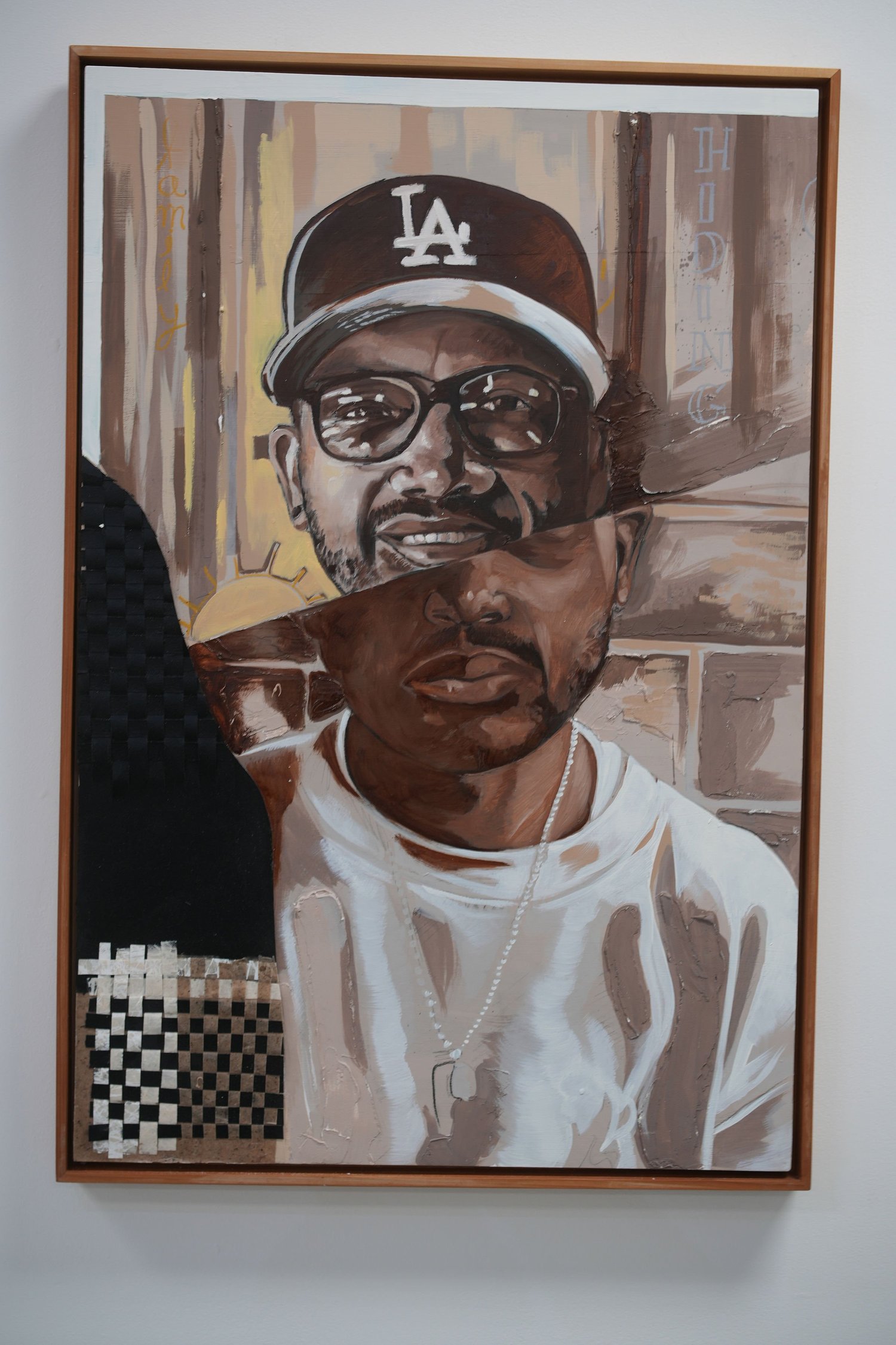 A framed portrait of a person wearing an LA cap.