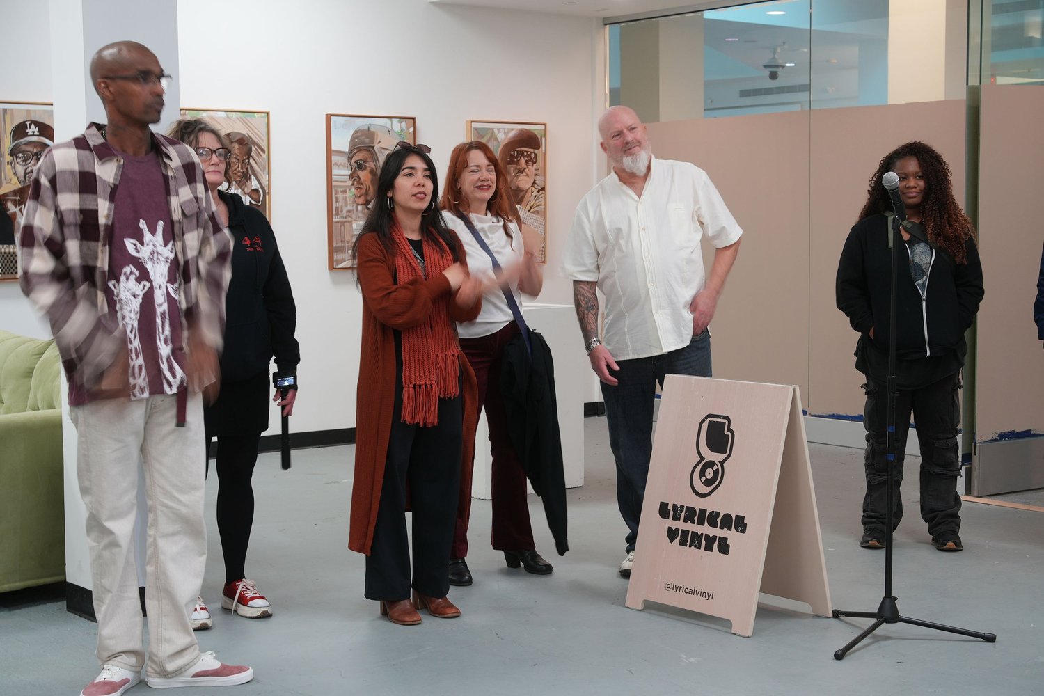 Guests gather and talk among the displayed artwork.
