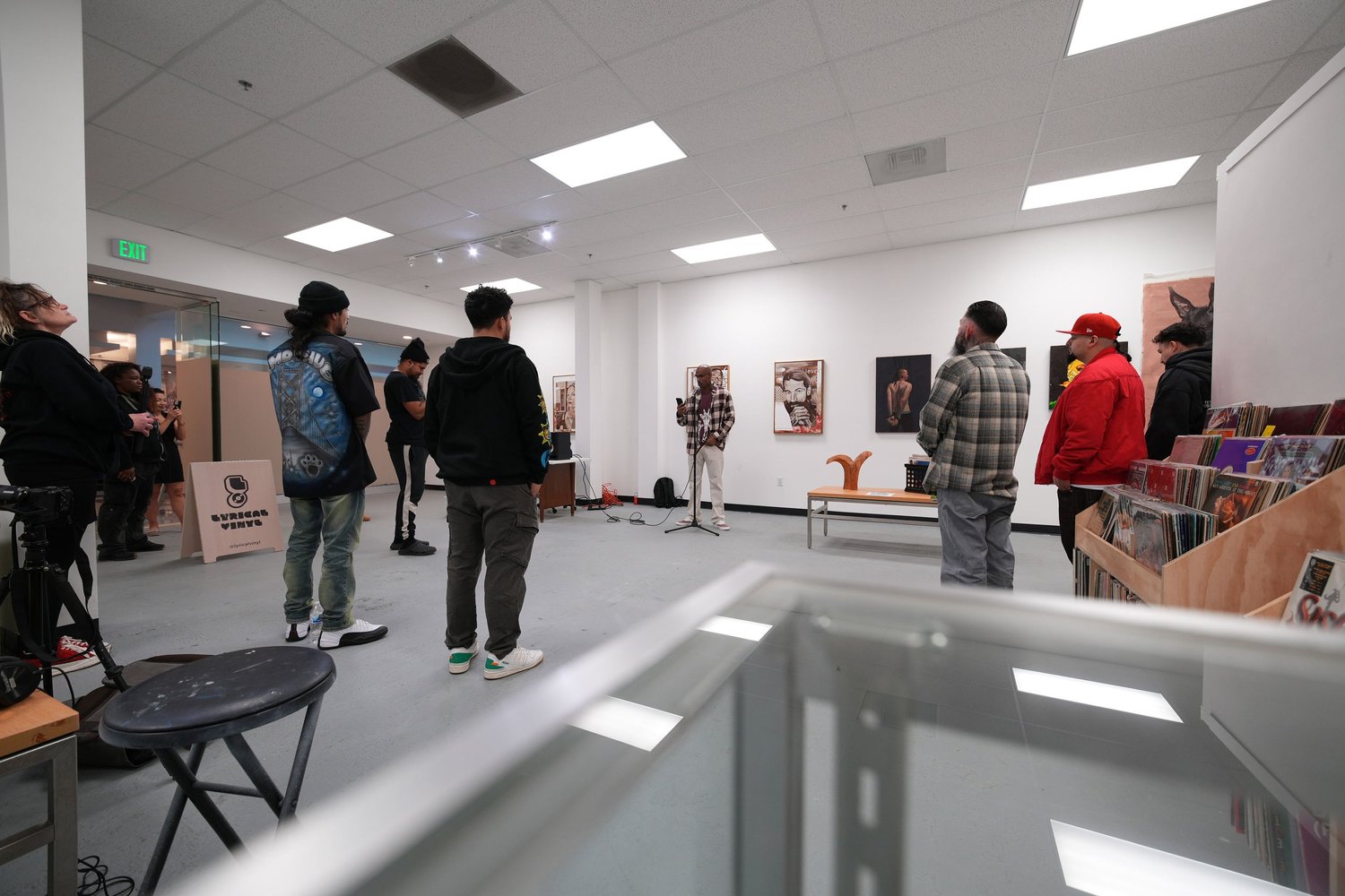 Guests gather and talk among the displayed artwork.