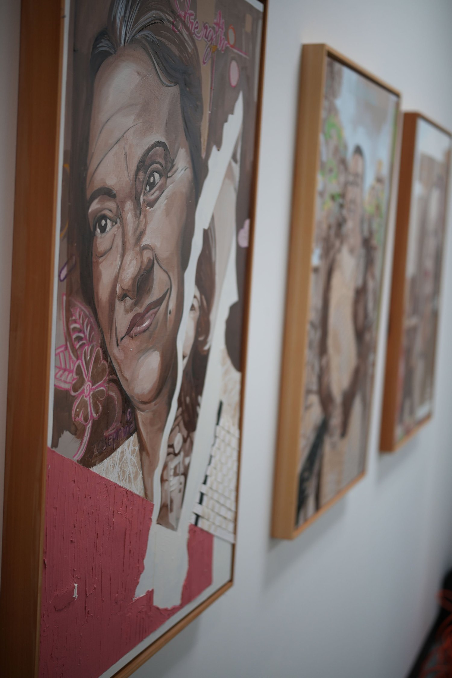 Framed painted portraits displayed in a row.