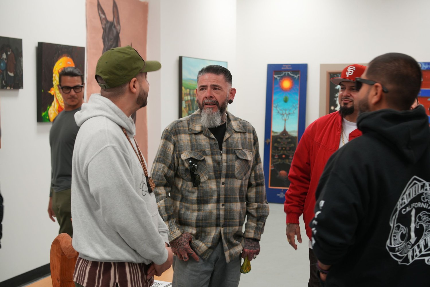 Guests gather and talk among the displayed artwork.
