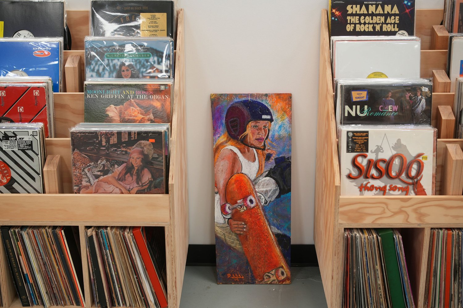 Record sleeves displayed beside painted skateboard artwork.