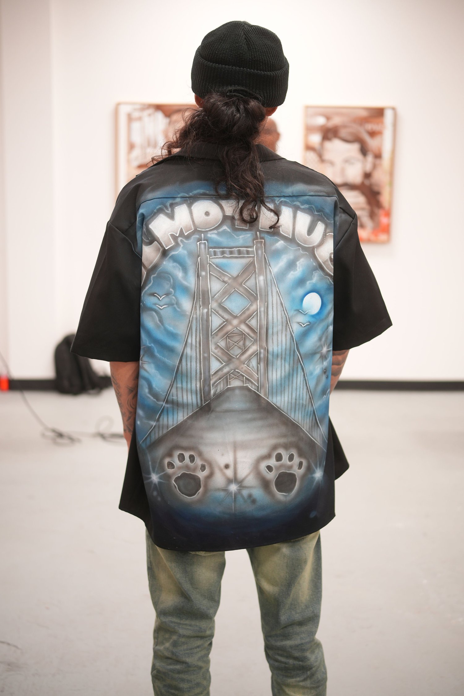 A visitor wearing an illustrated jacket studies the exhibition.