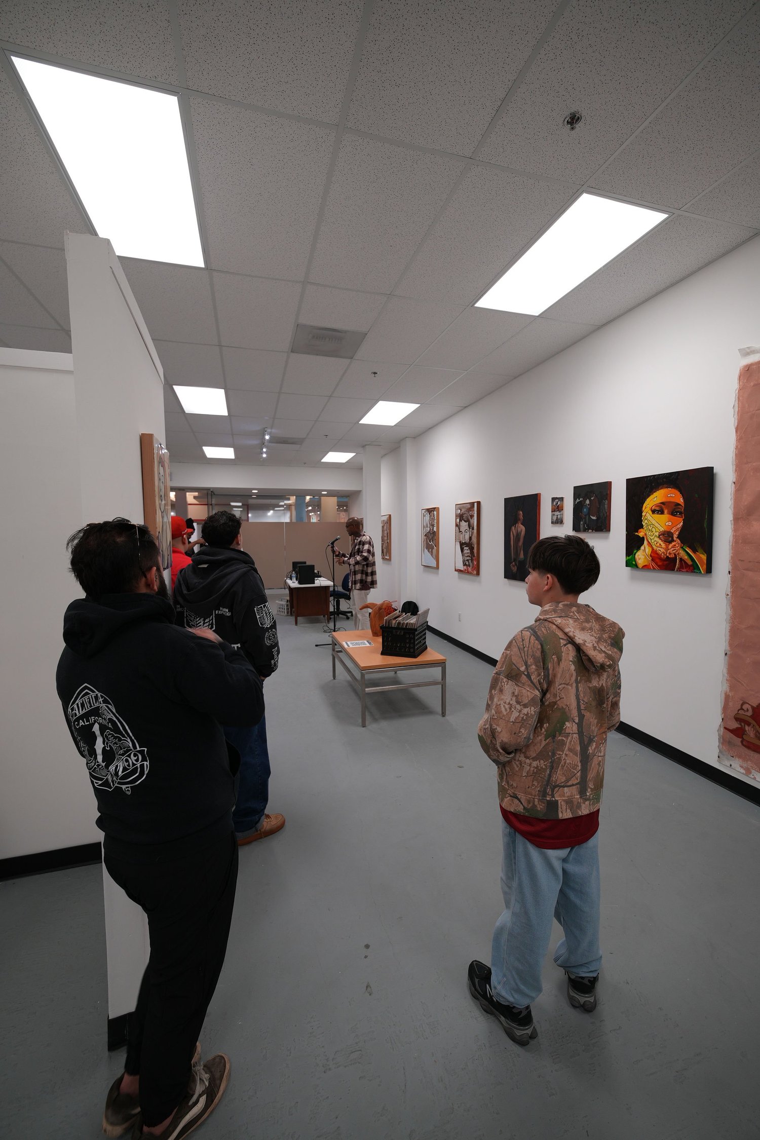 Guests gather and talk among the displayed artwork.