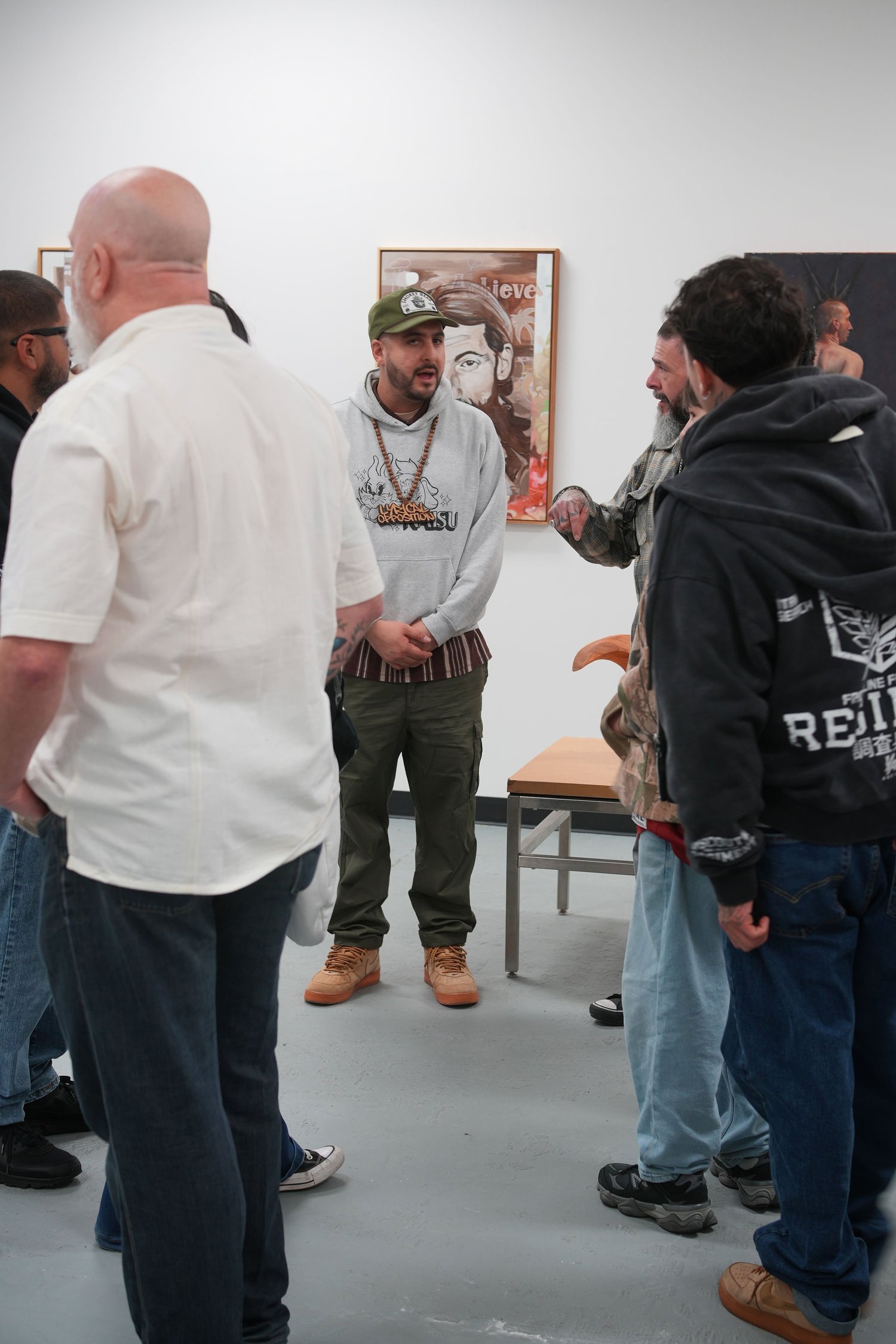 Guests gather and talk among the displayed artwork.