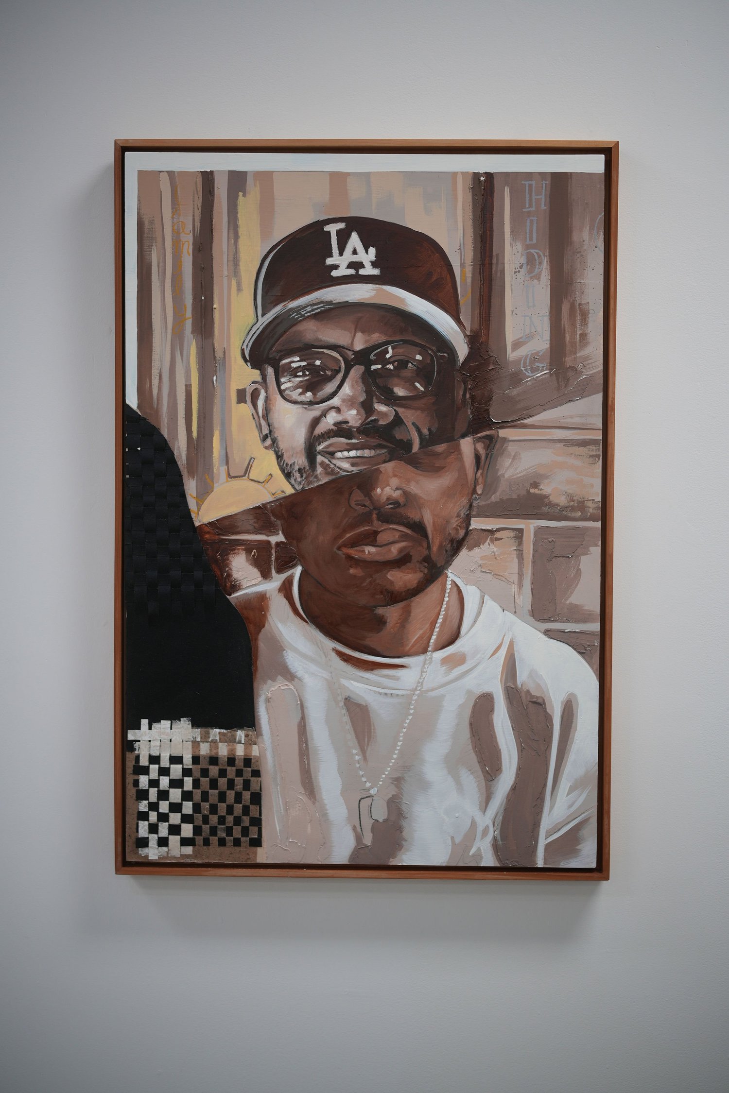 A framed portrait of a person wearing an LA cap.