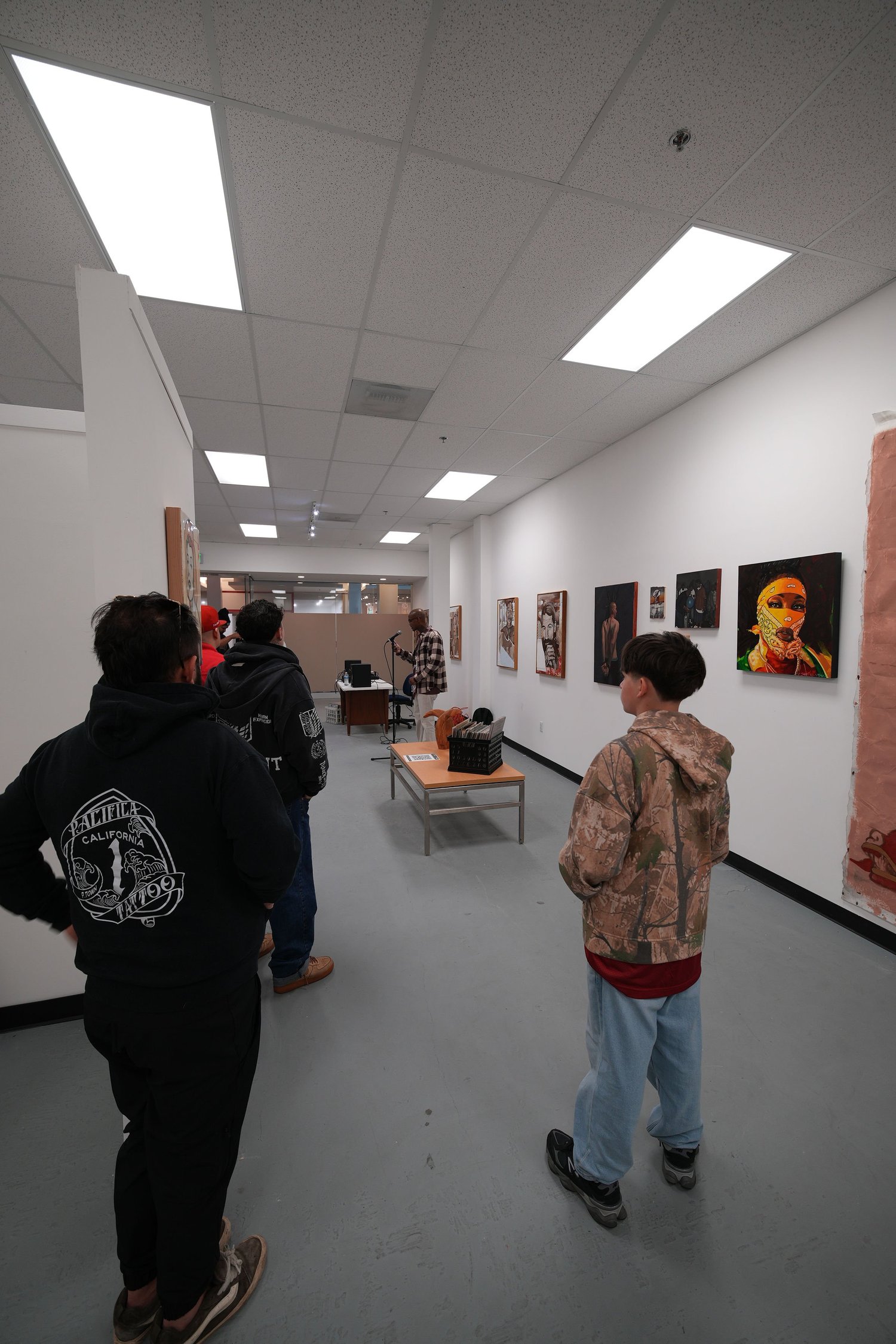 Guests gather and talk among the displayed artwork.