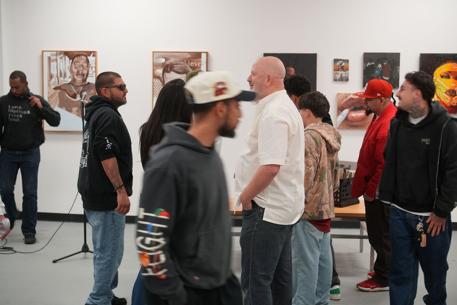 Visitors converse among the gallery artwork.