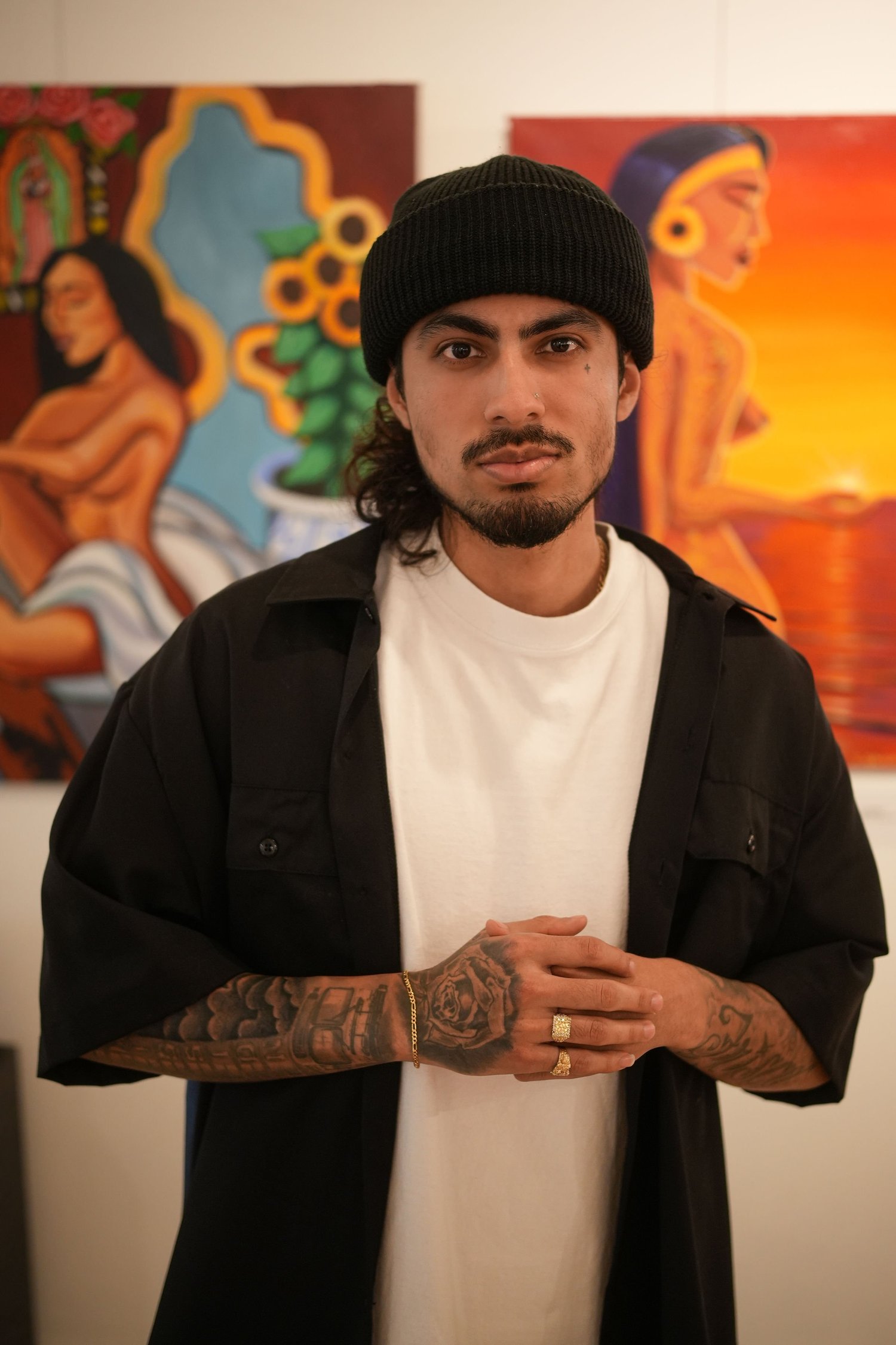An artist poses in front of the exhibition artwork.