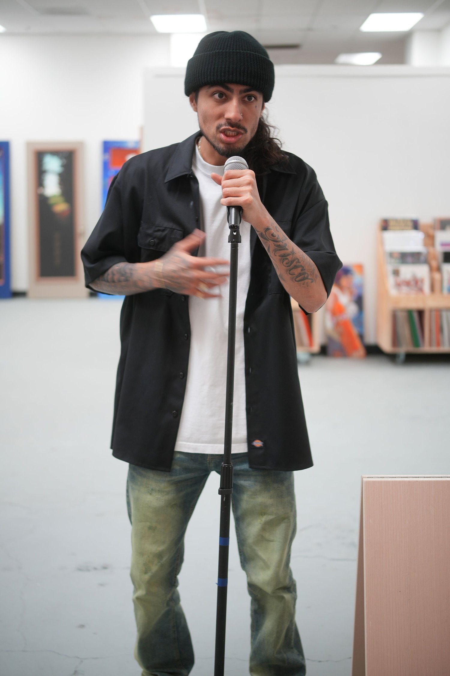 A speaker addresses gallery visitors with a microphone.