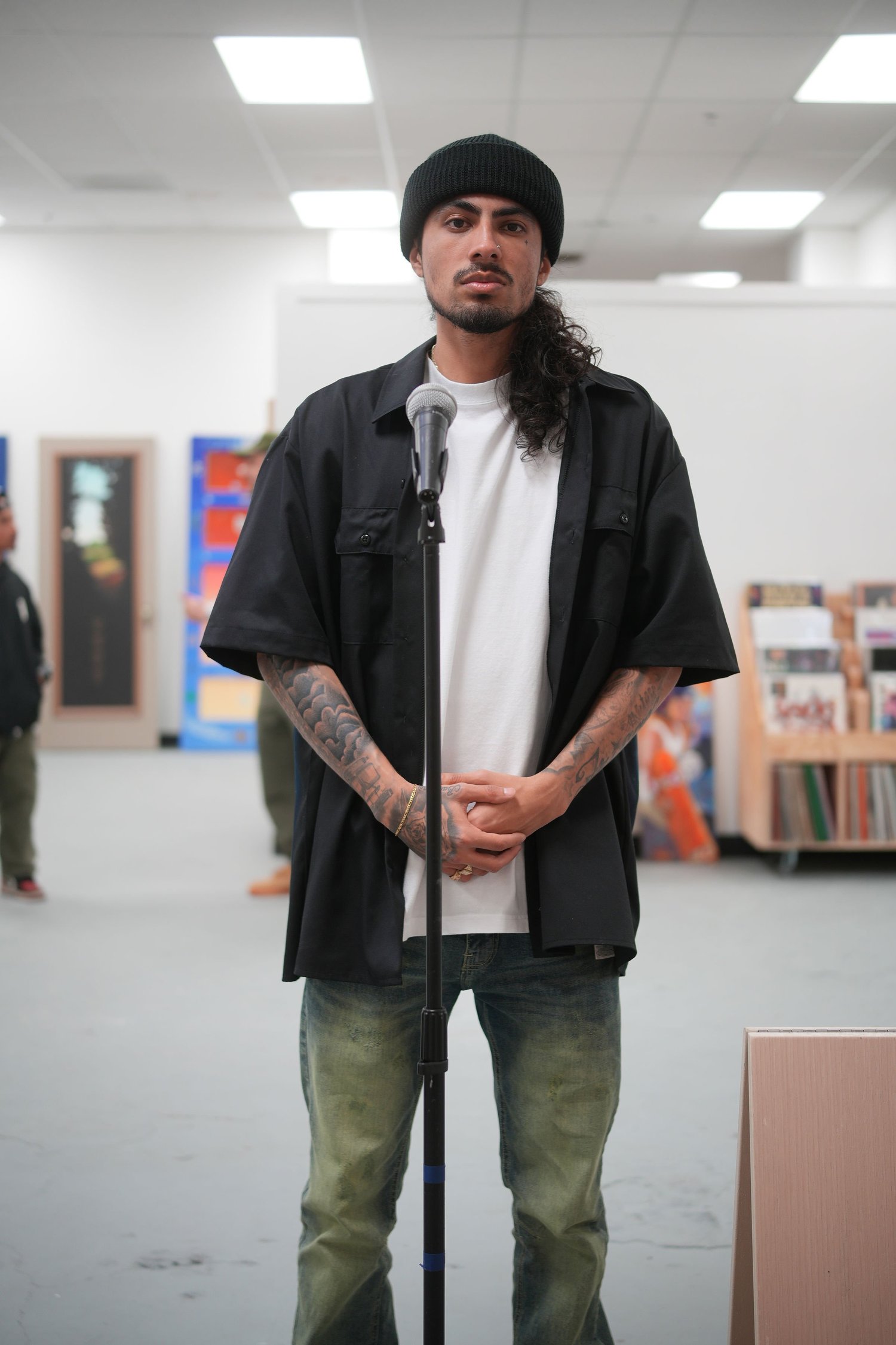 An artist poses in front of the exhibition artwork.