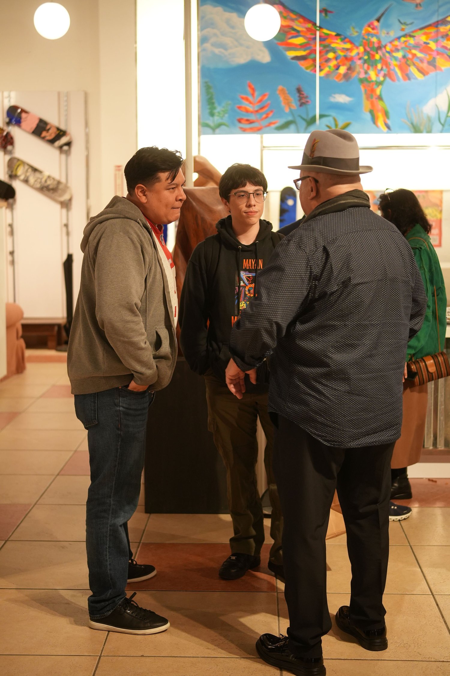 Visitors converse among the gallery artwork.