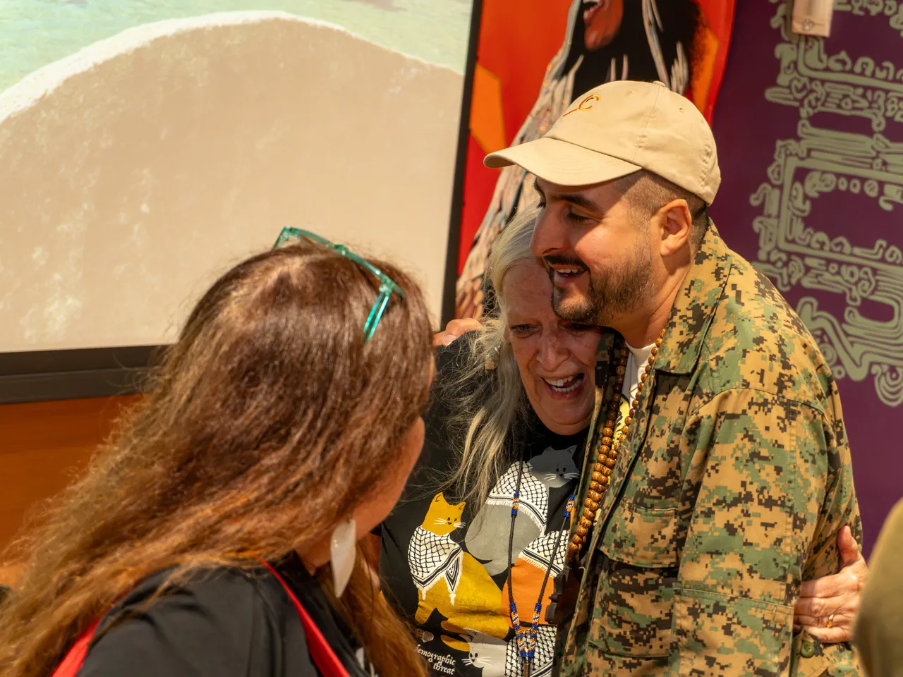 Two smiling guests lean toward each other during a conversation.