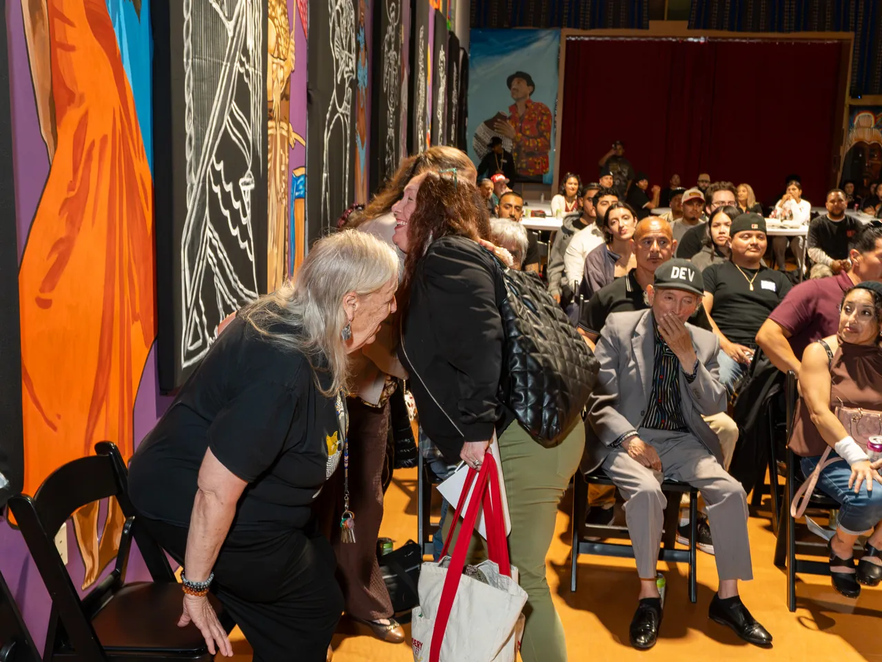 Guests stand and move between rows of chairs in the screening room.