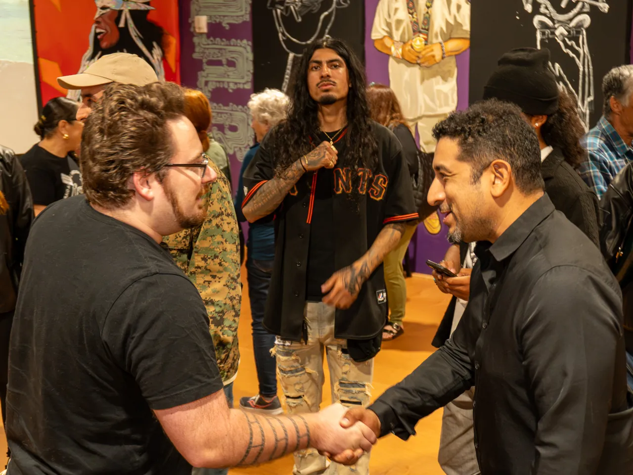Guests shake hands while others stand nearby.