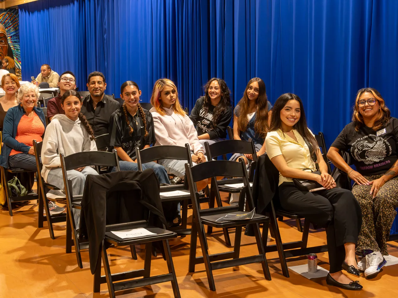 Guests seated in the front rows look toward the camera.