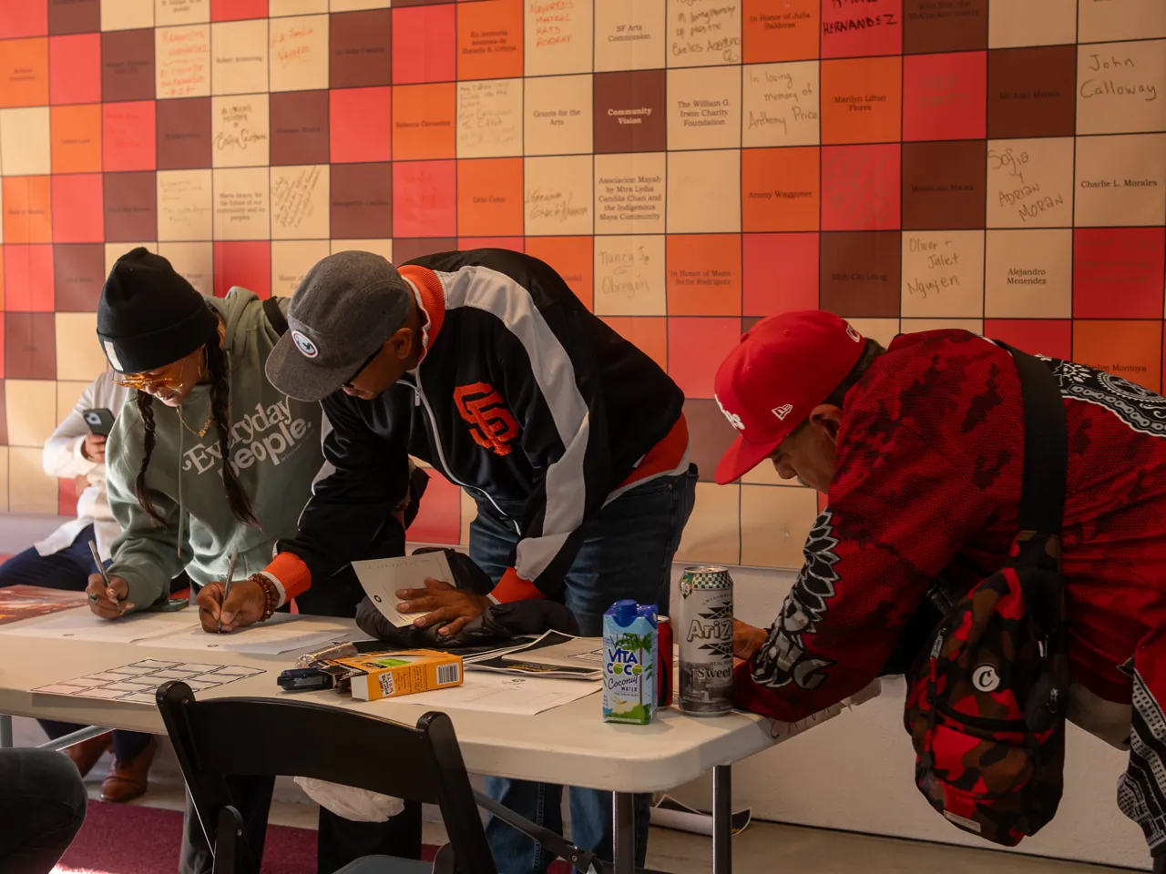 Guests lean over the welcome table to complete paperwork.